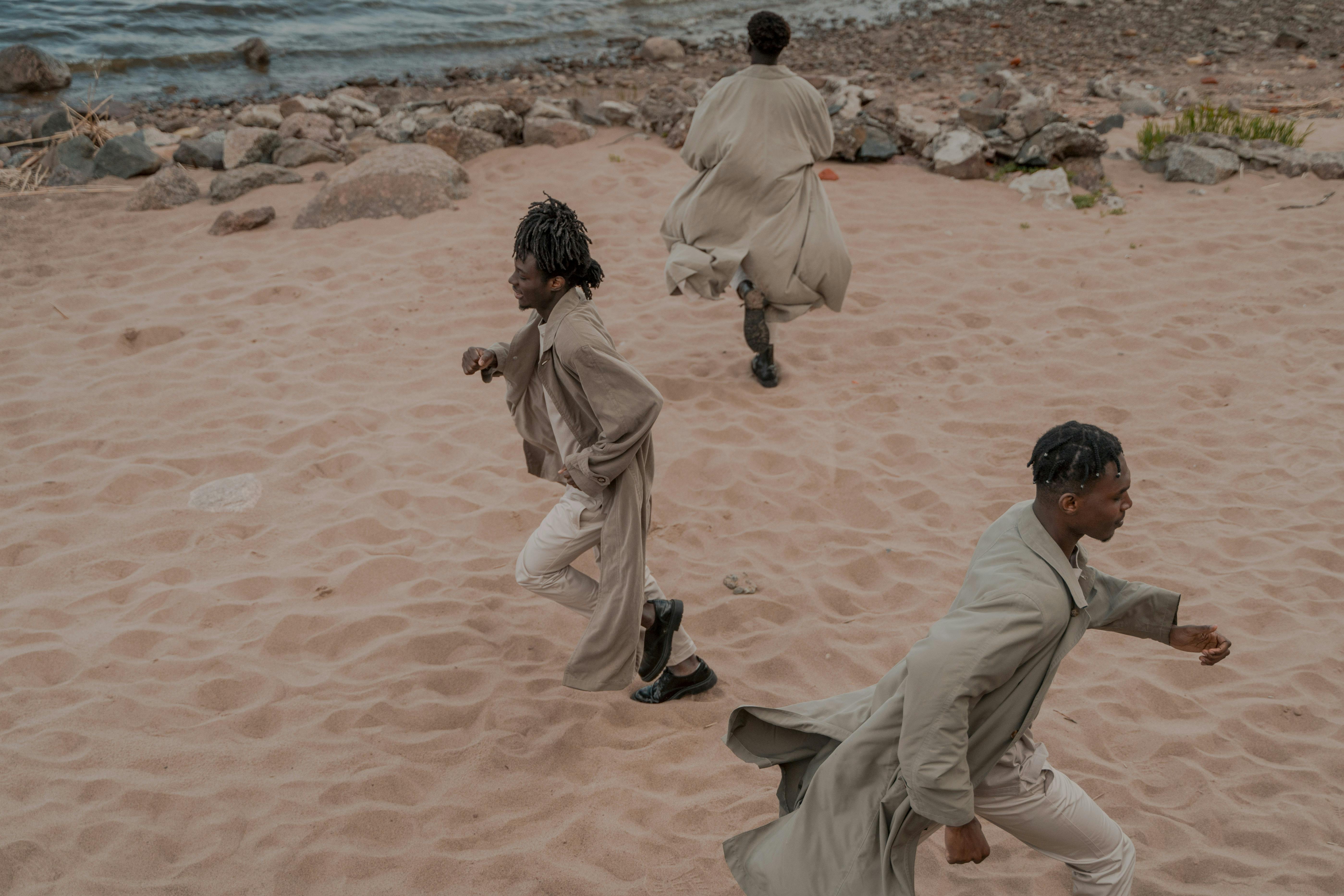 Men on Beach Running in Different Directions