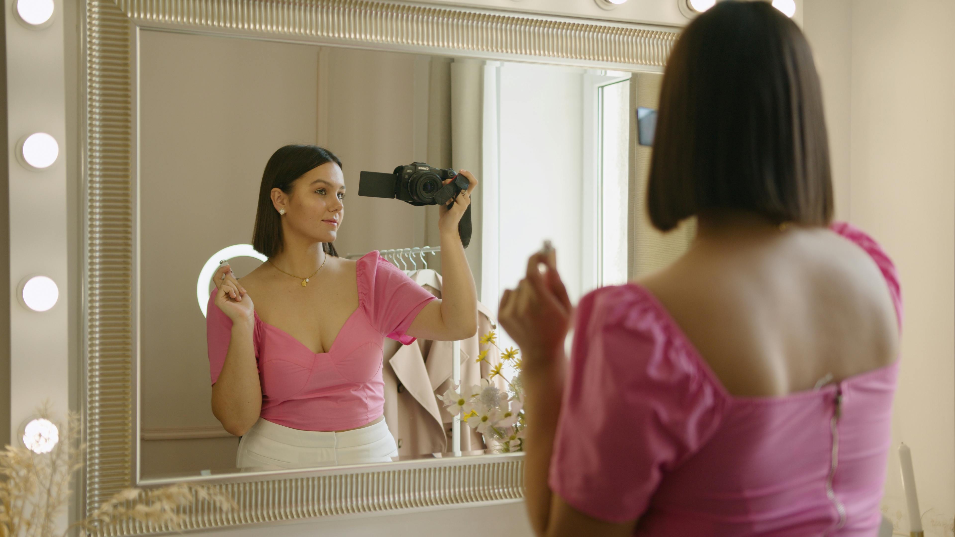 Reflection of a Woman in Pink Blouse Recording Herself