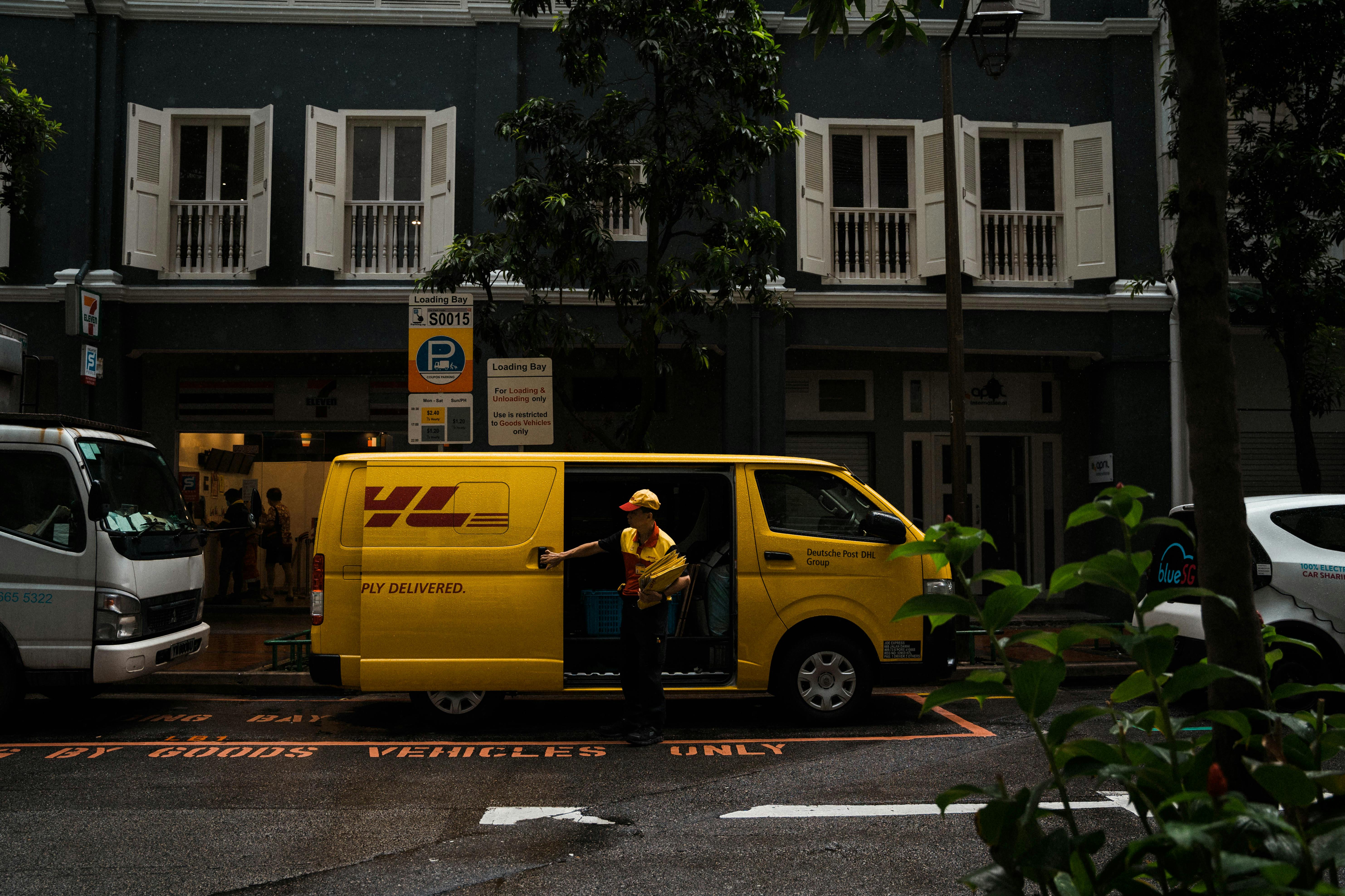 Yellow Van in front of a House and Man Delivering Post