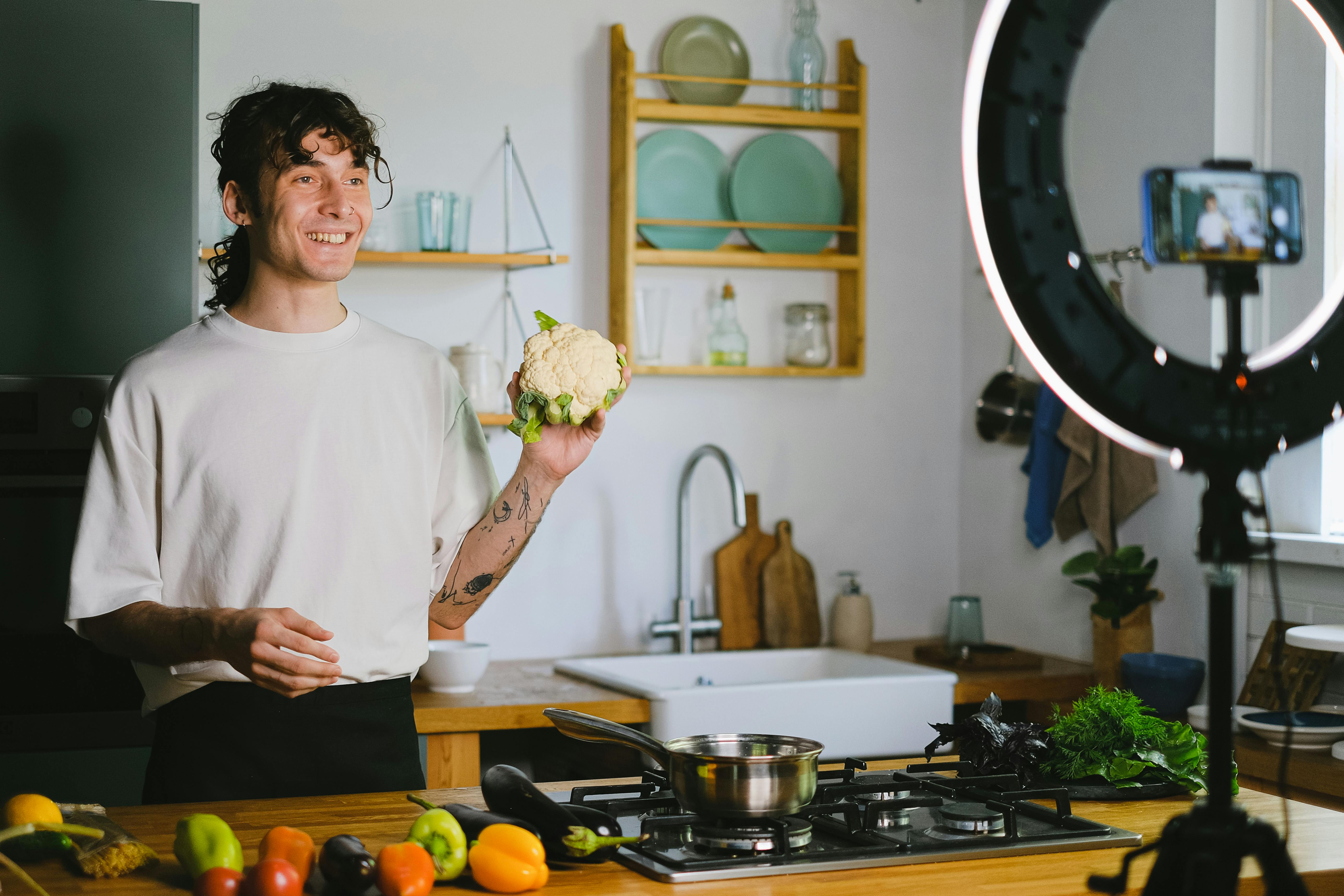 Man in White Shirt Holding a Broccoli in the Kitchen