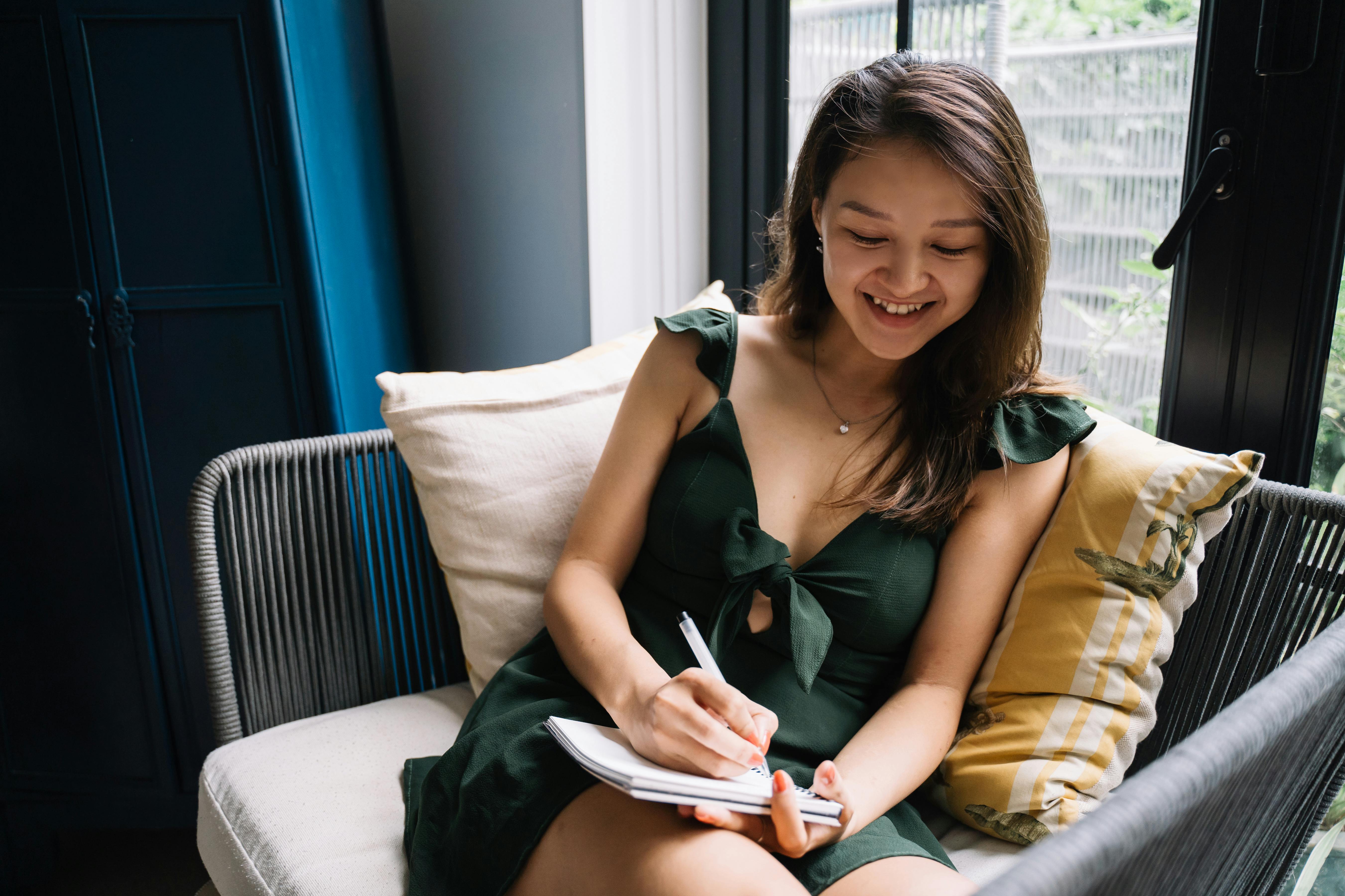 Young Woman Sitting on a Couch with a Notepad