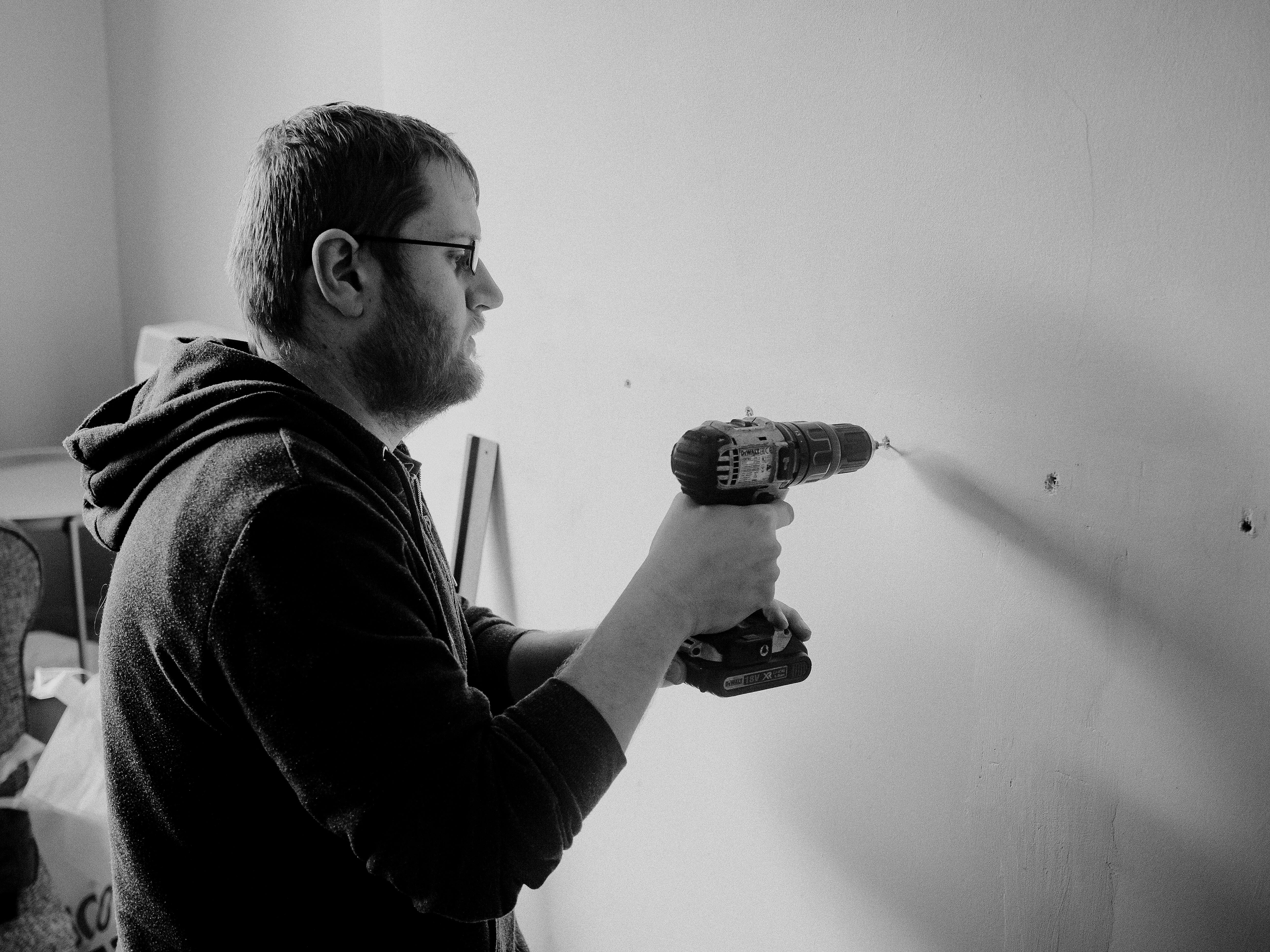 Man Drilling Wall in House