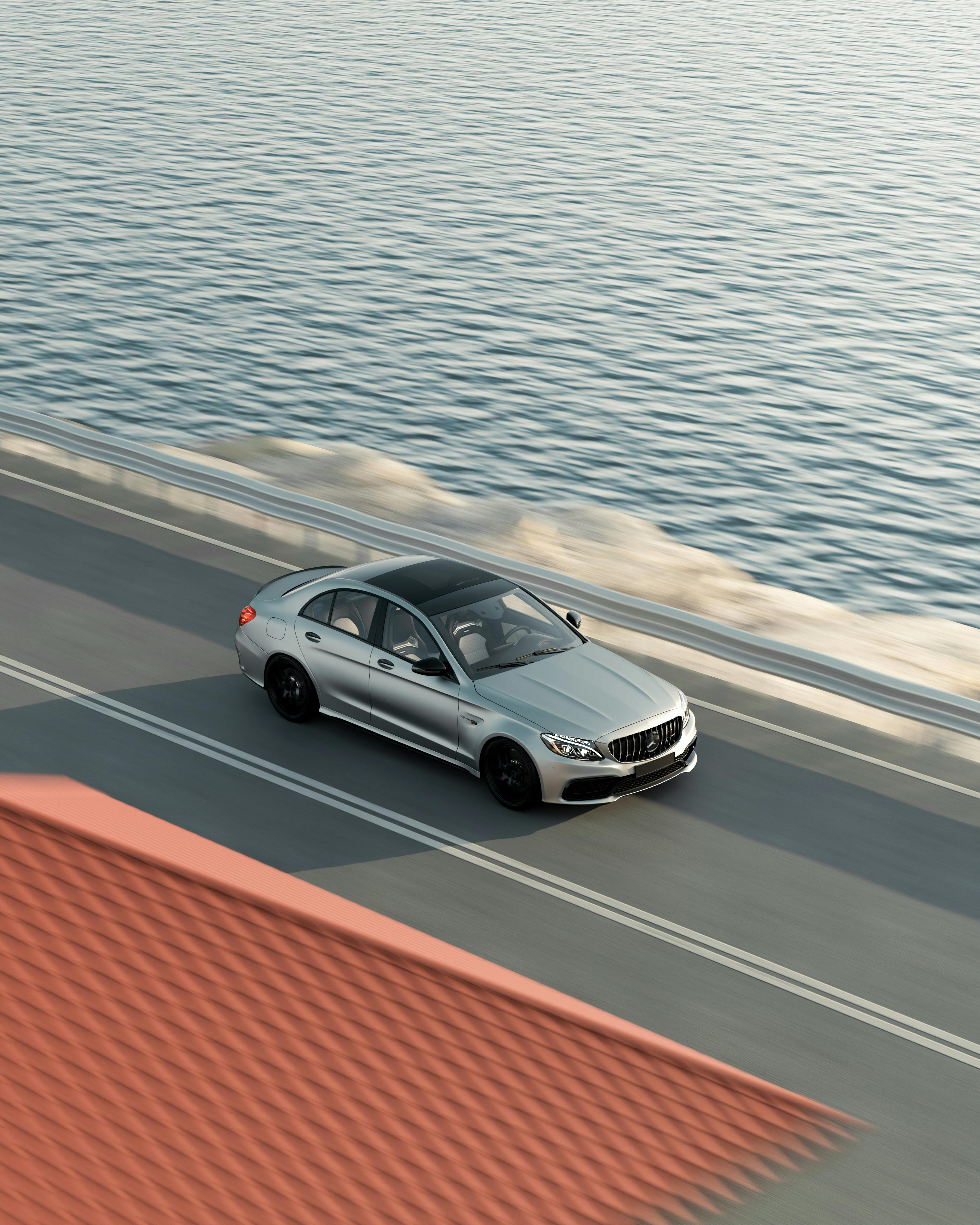 Luxury Silver Car Driving on Coastal Road