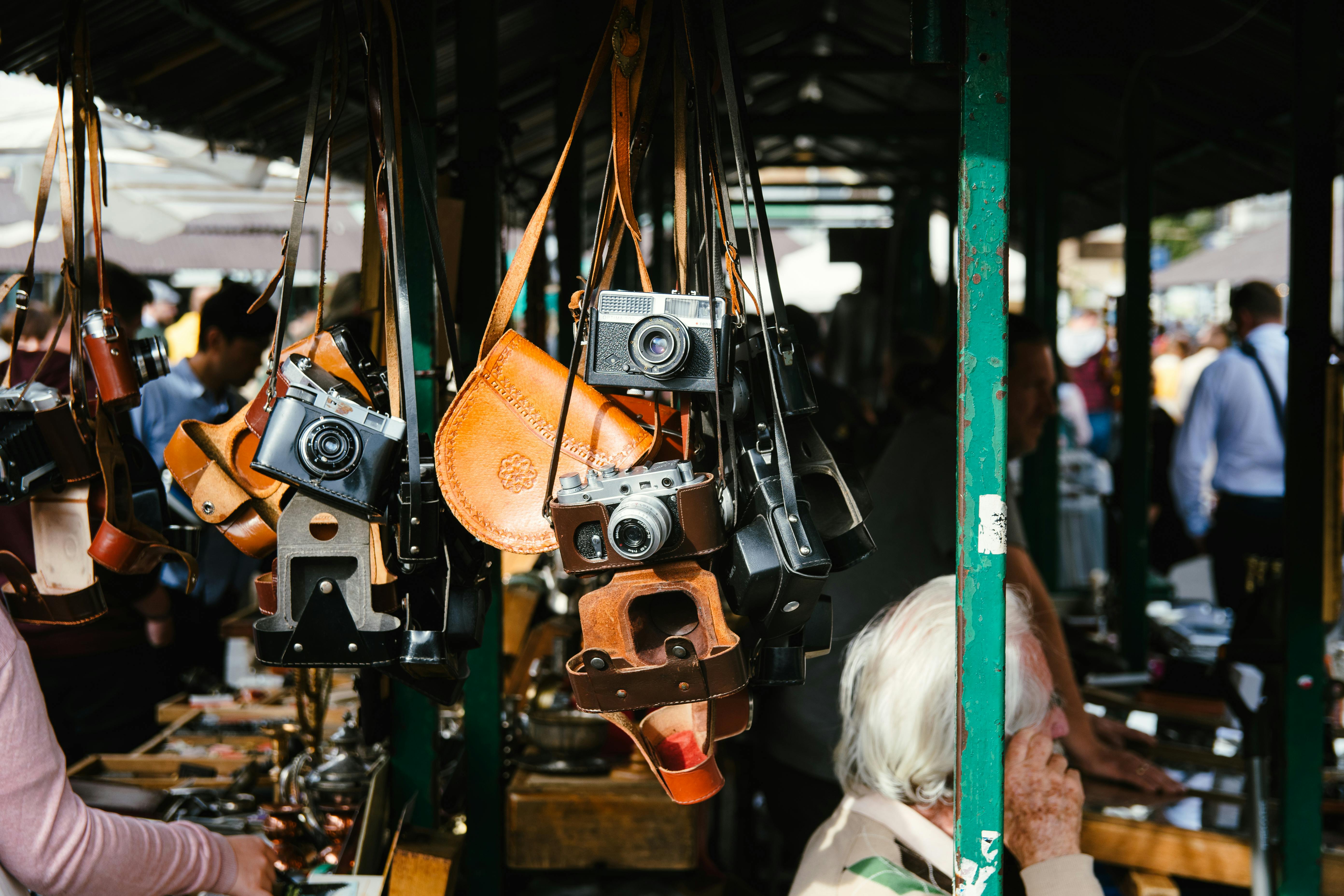 People Standing Near Store and Different Cameras Hanging
