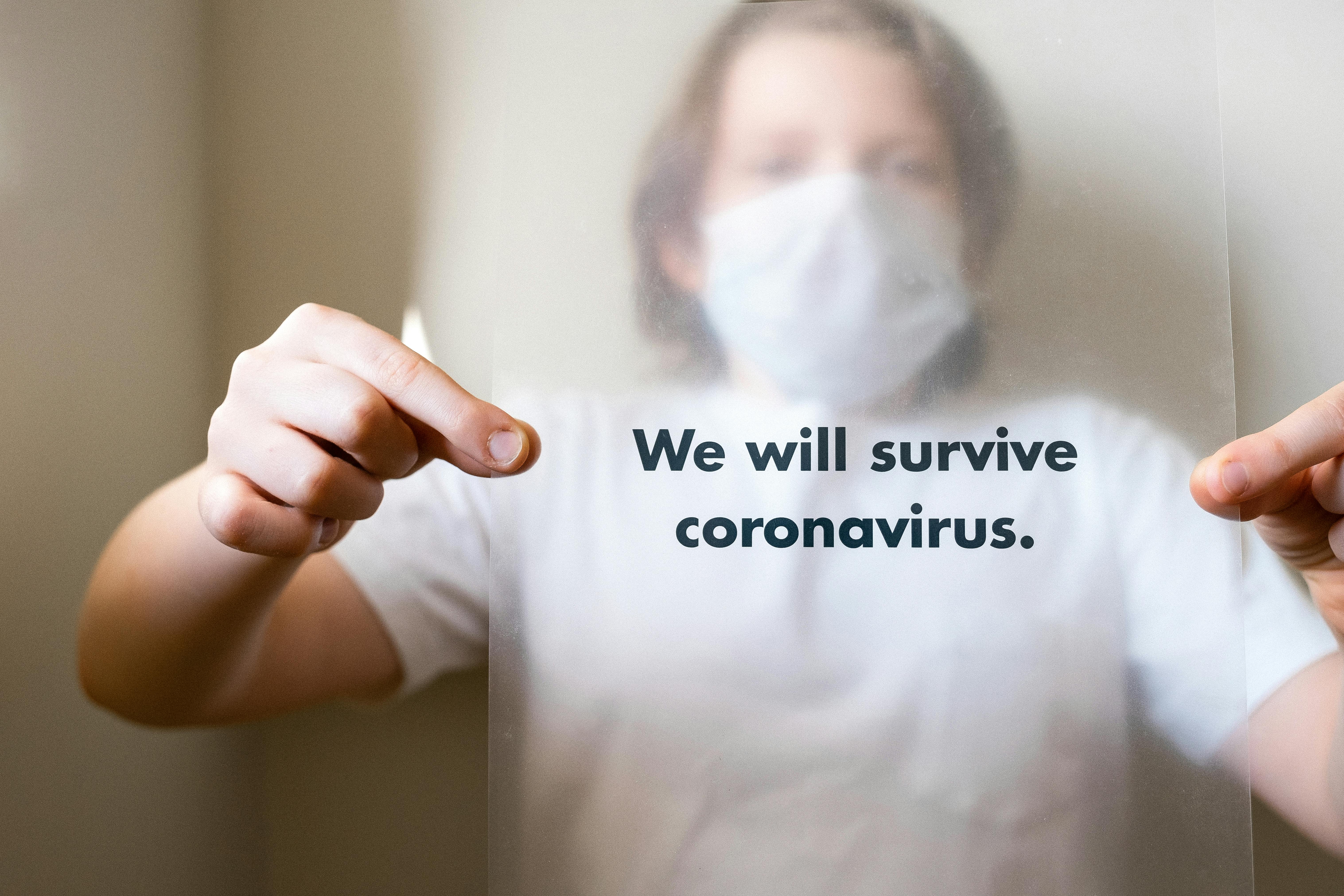 Man in White Crew Neck T-shirt Holding A Slogan On Coronavirus