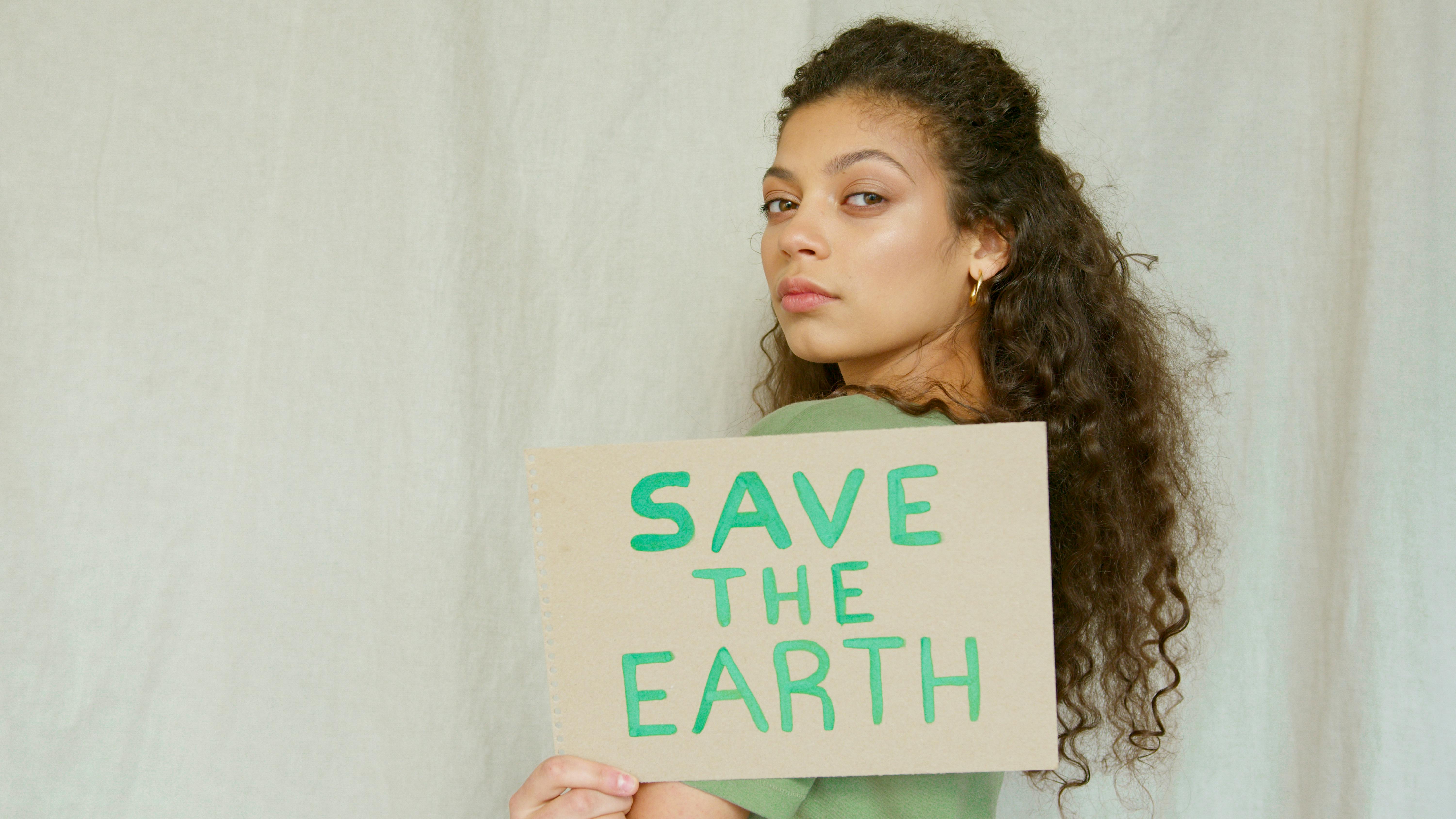 Woman Holding a Save the Earth Cardboard