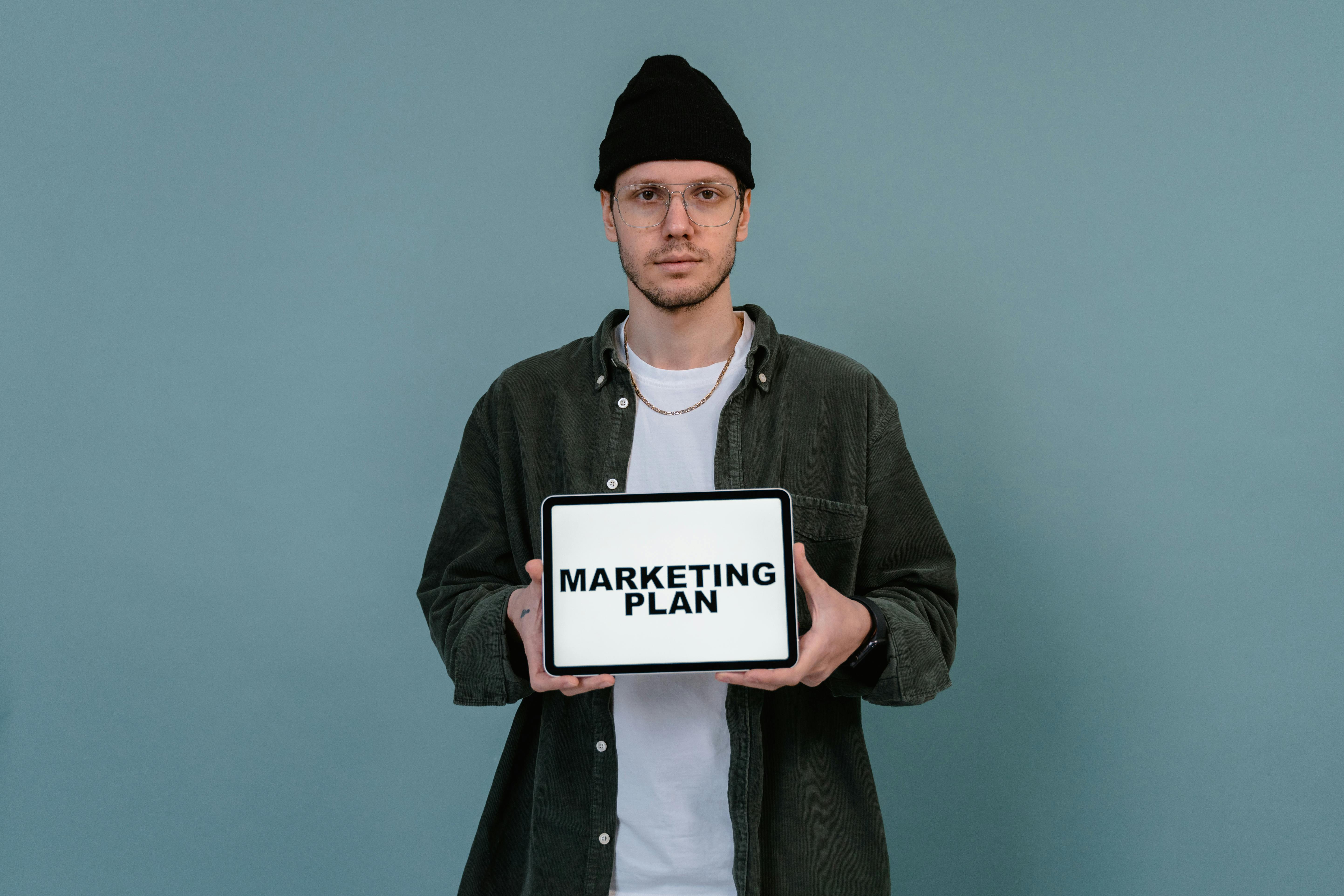 Man in Black Beanie Hat Holding White Tablet Computer with Message 