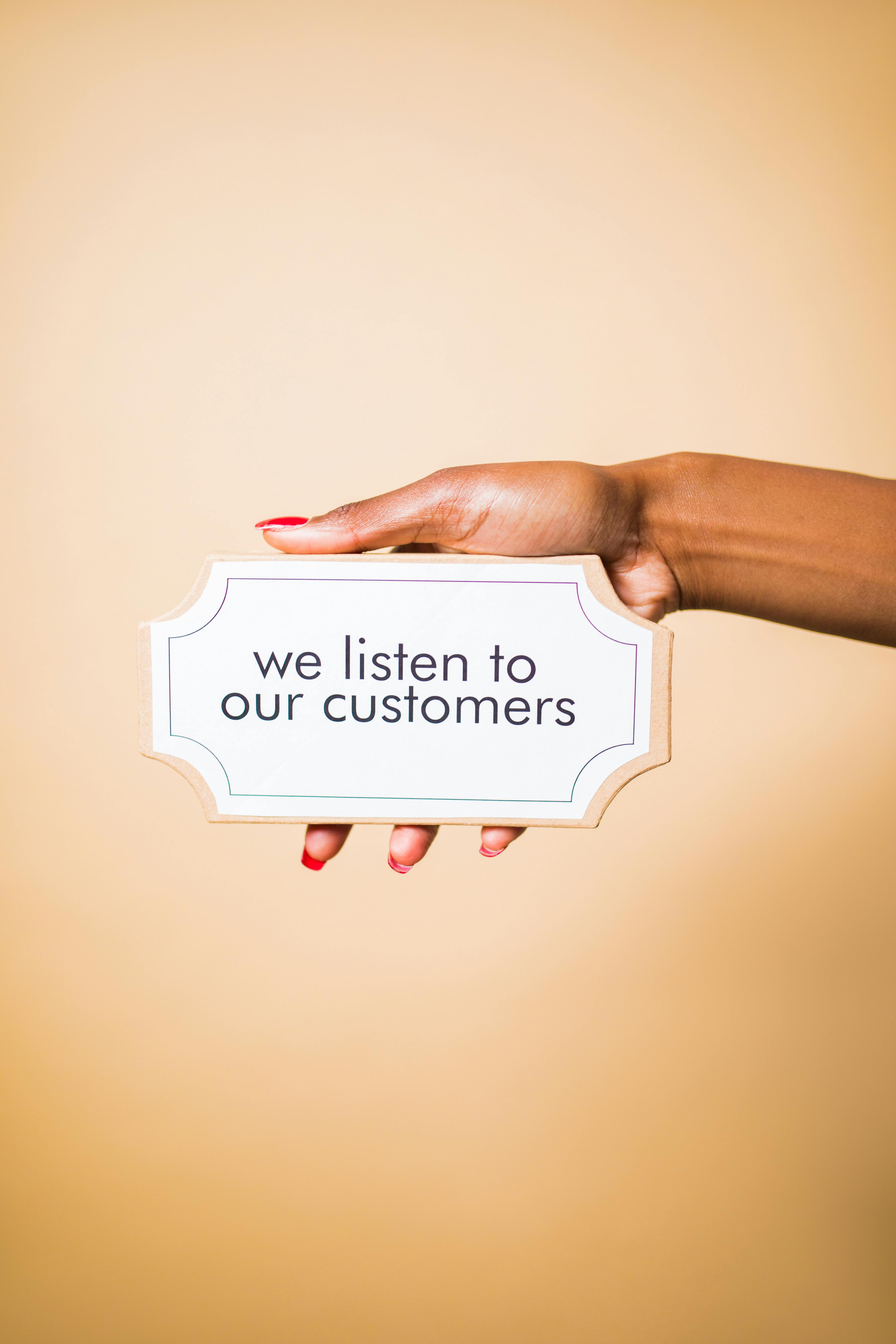 Person Holding a Board with a Text Saying 