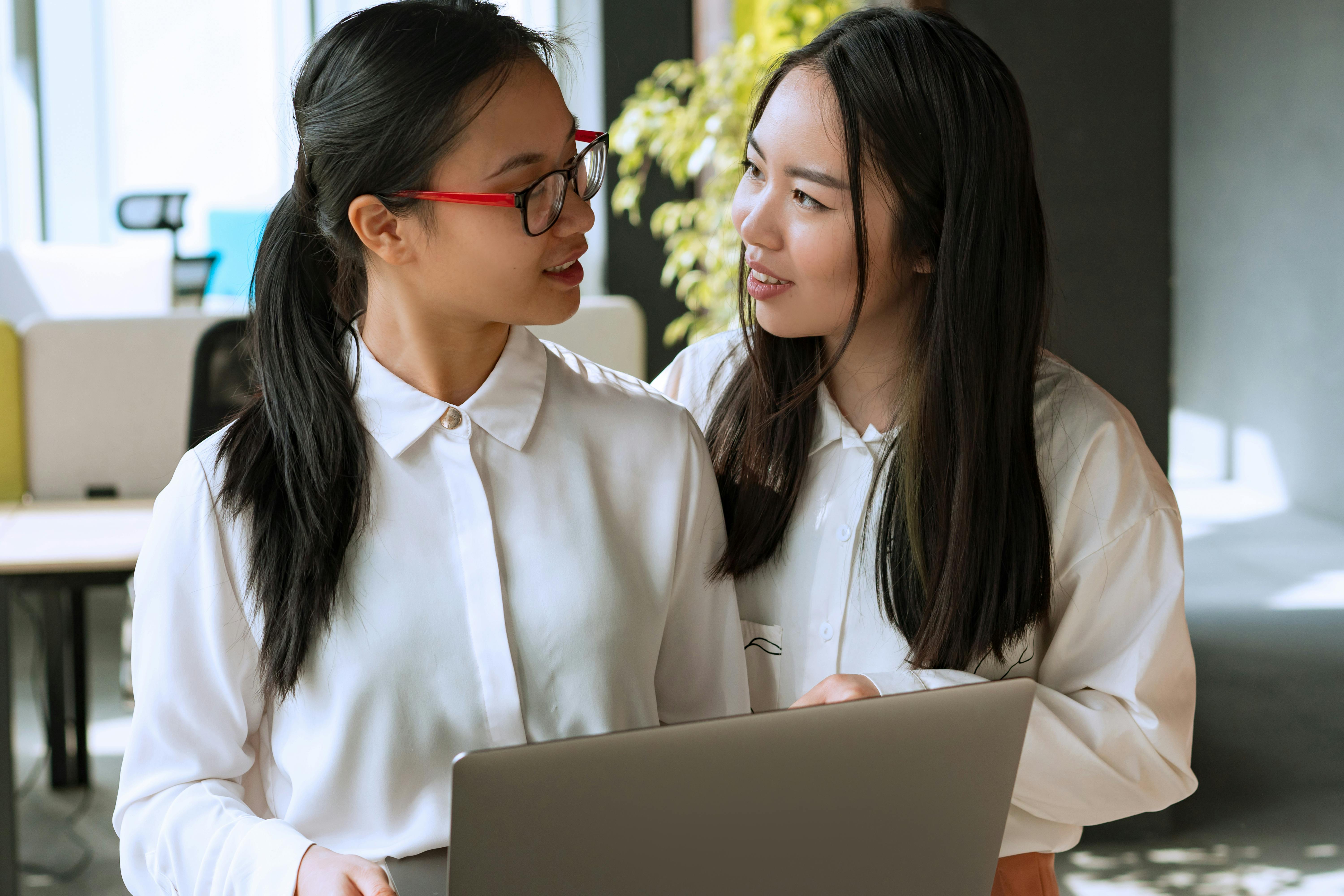 Two Women in White Dress Shirt Having a Conversation