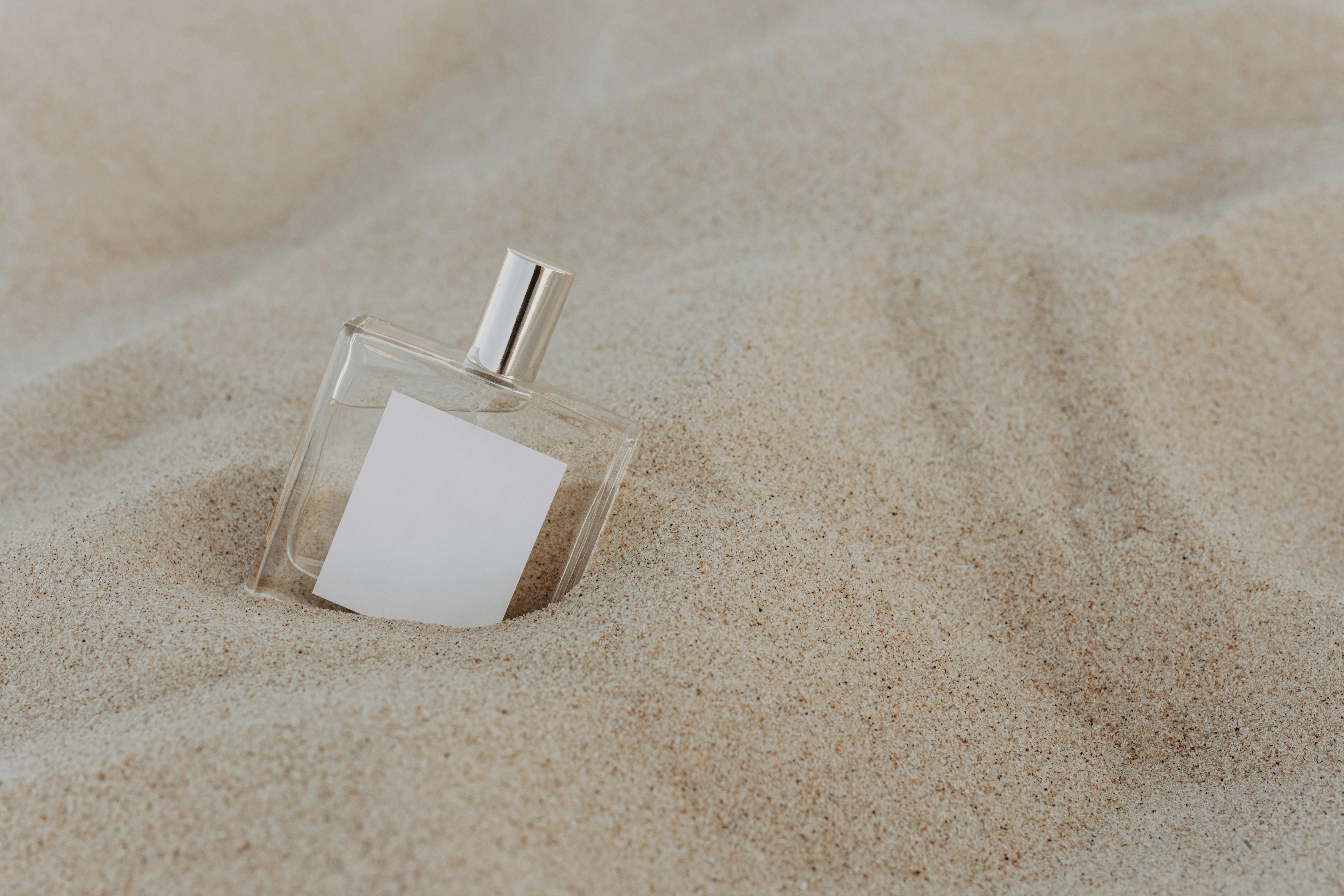 Close-Up Shot of a Perfume Bottle on the Sand