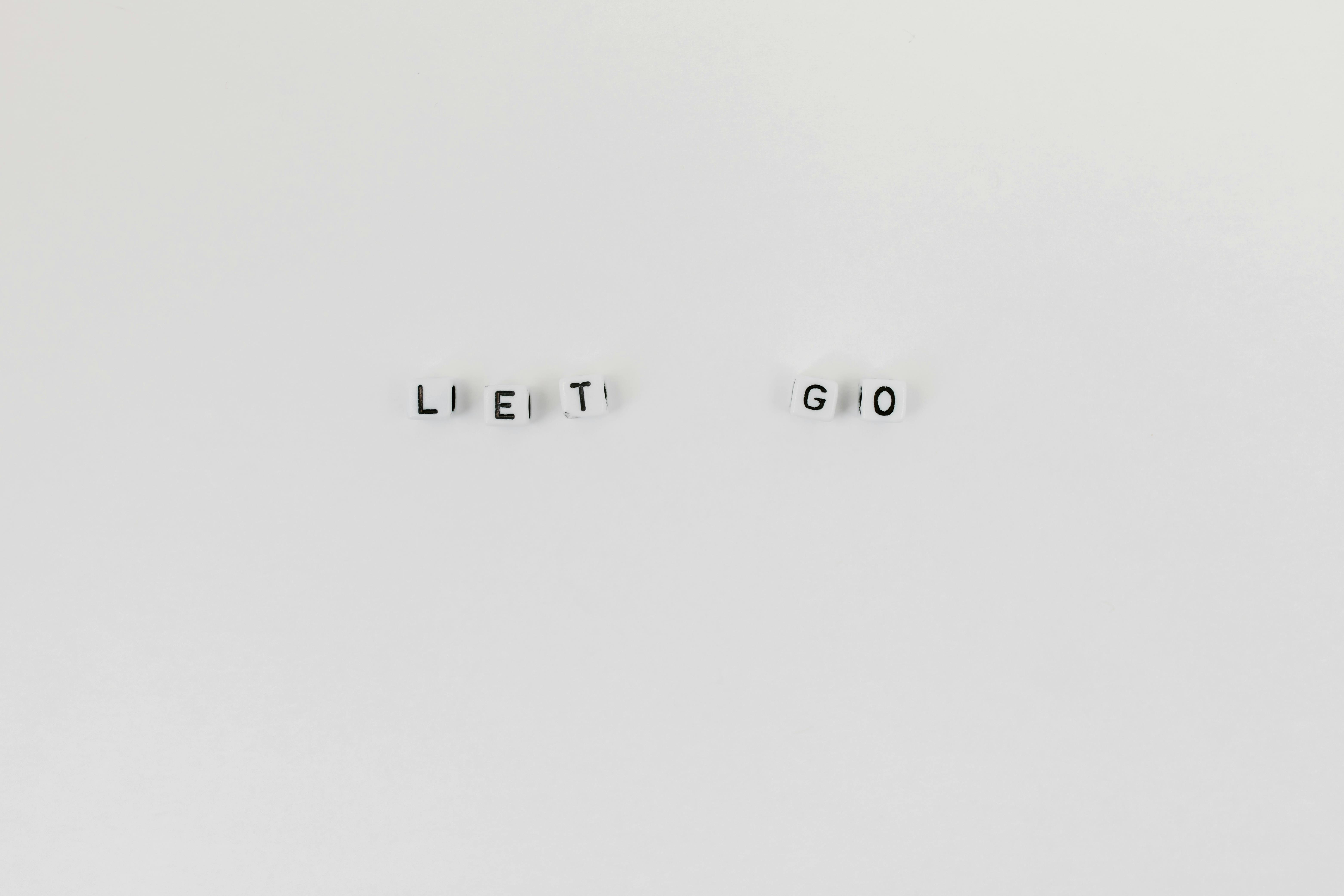 A Slogan Let Go Spelled with Letter Dice on White Background