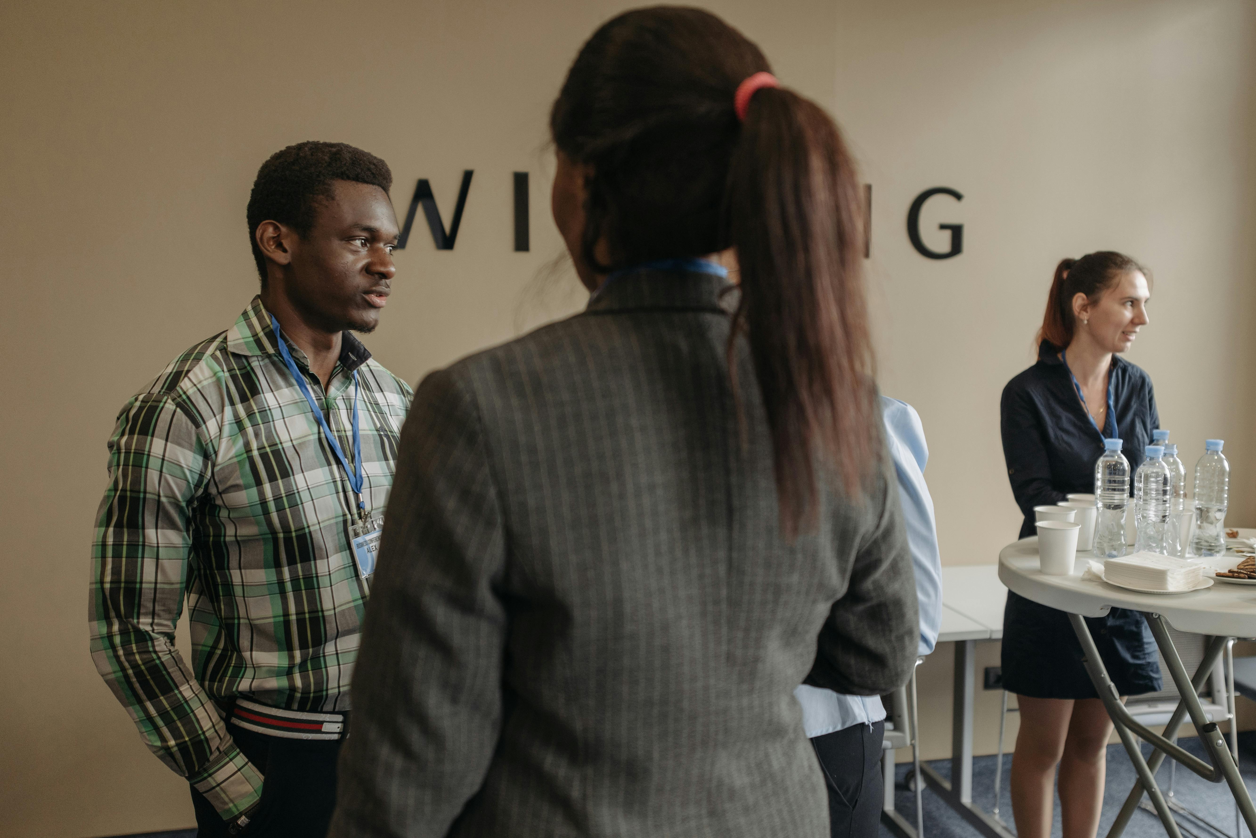 People Wearing Long Sleeves Standing in a Conference Room