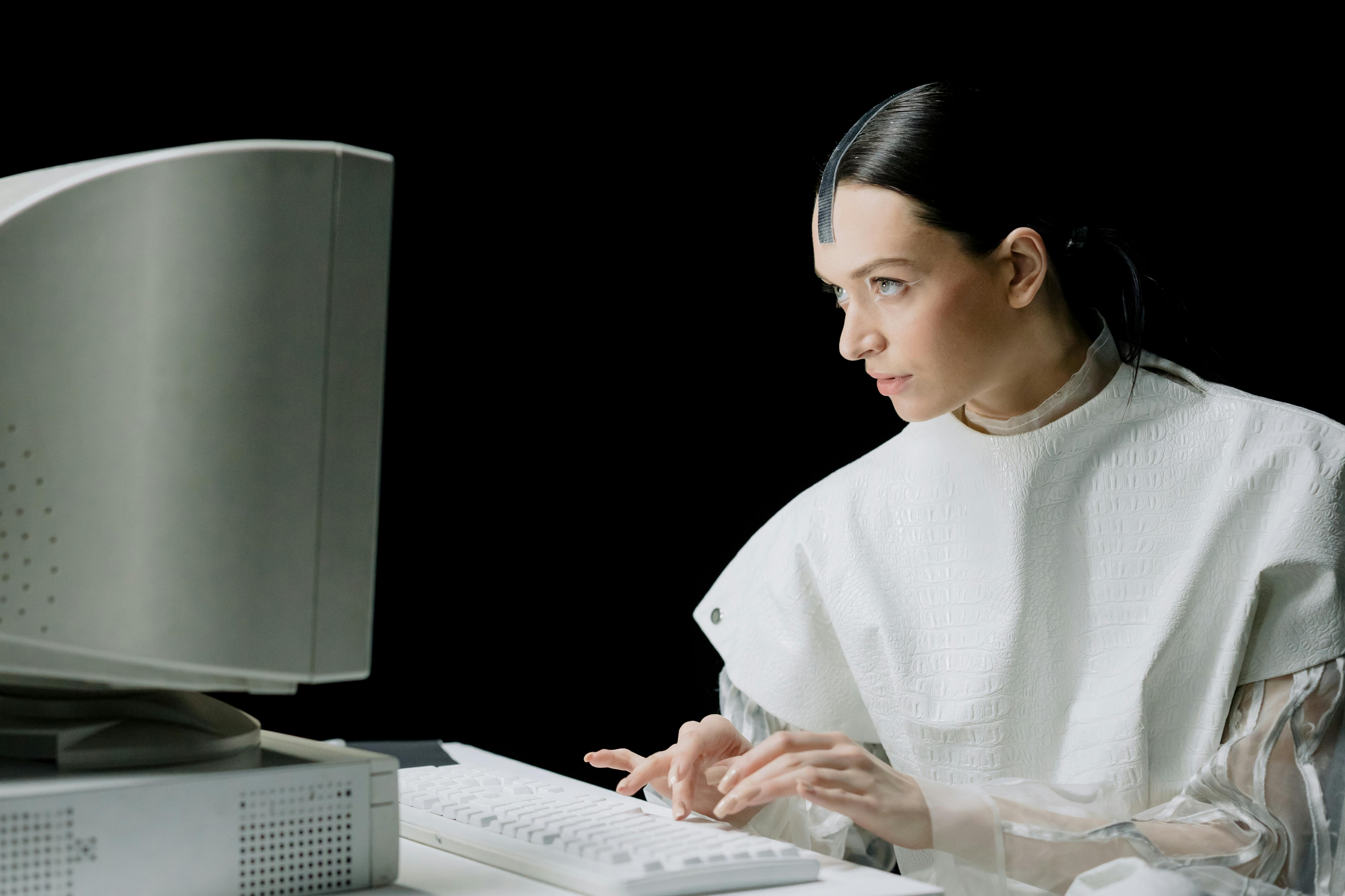 Woman in White Top Using a Computer