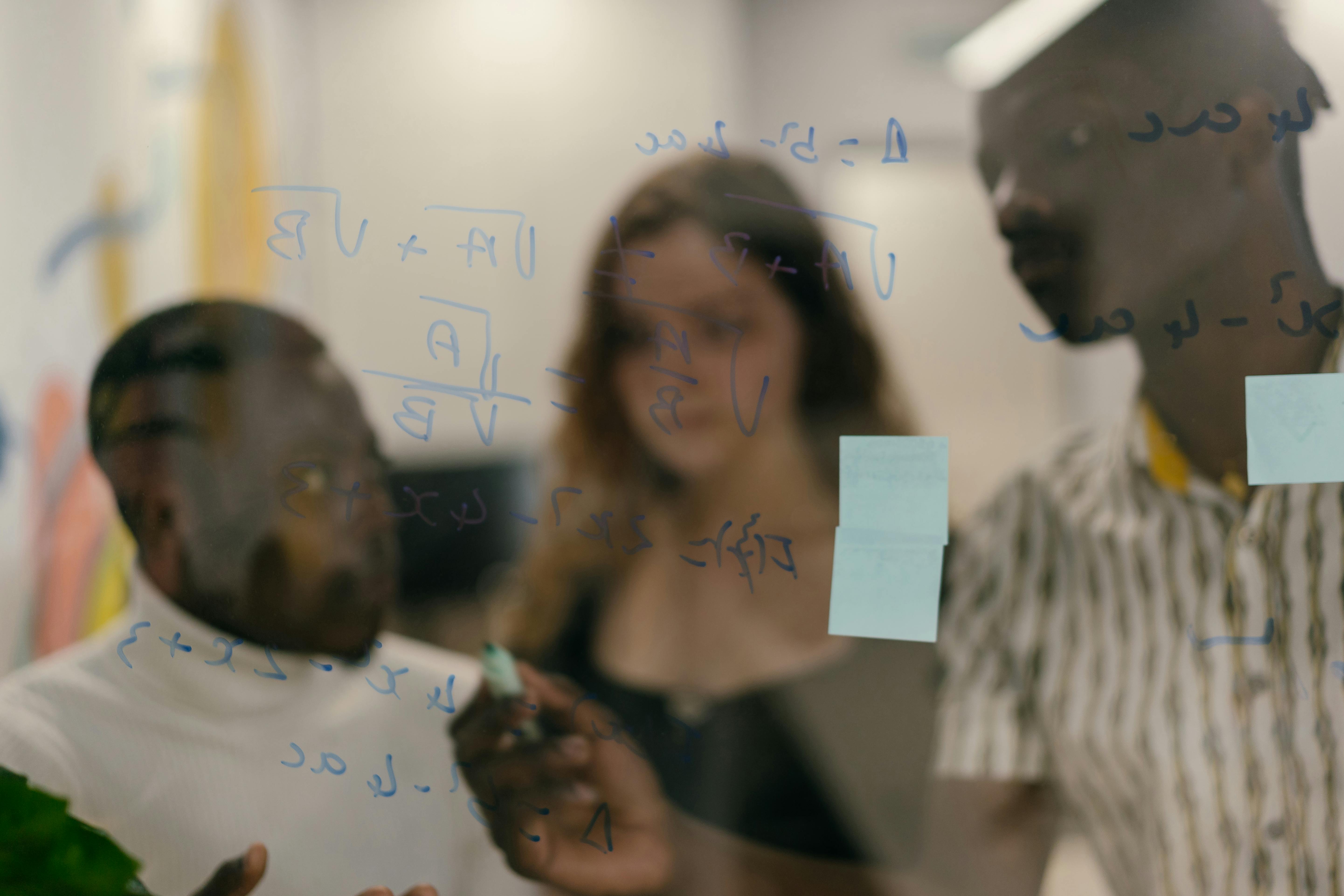 A Man Writing an Equation in a Glass Panel