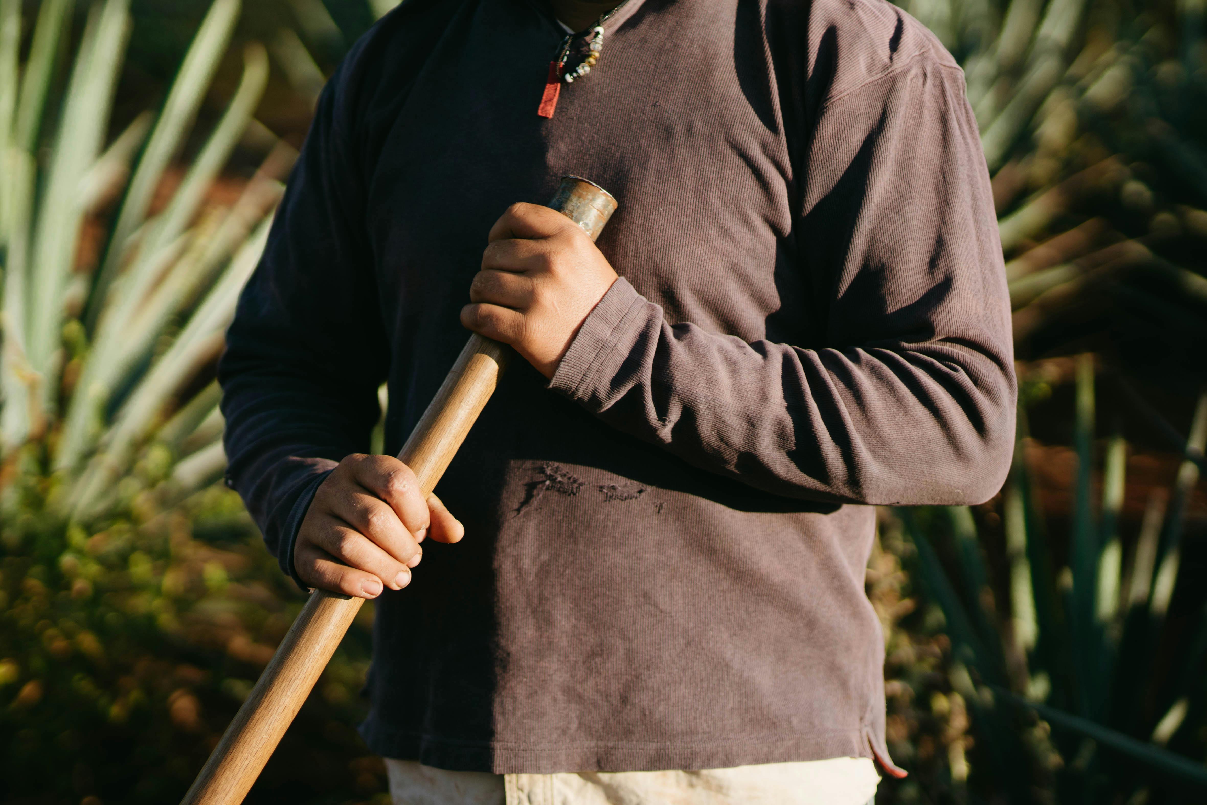 A Person Holding a Wooden Rod