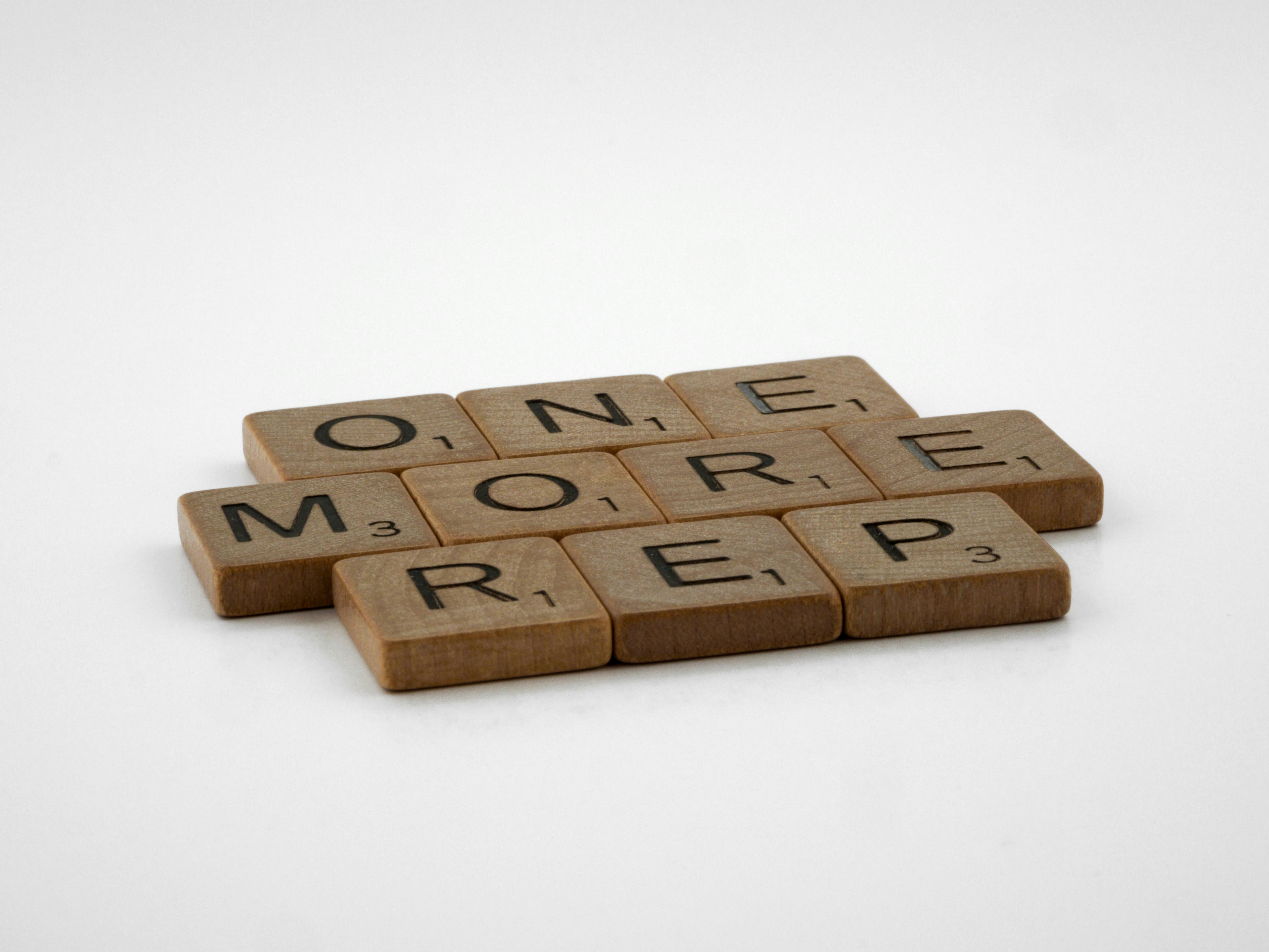 Close-Up Shot of Scrabble Tiles on White Surface