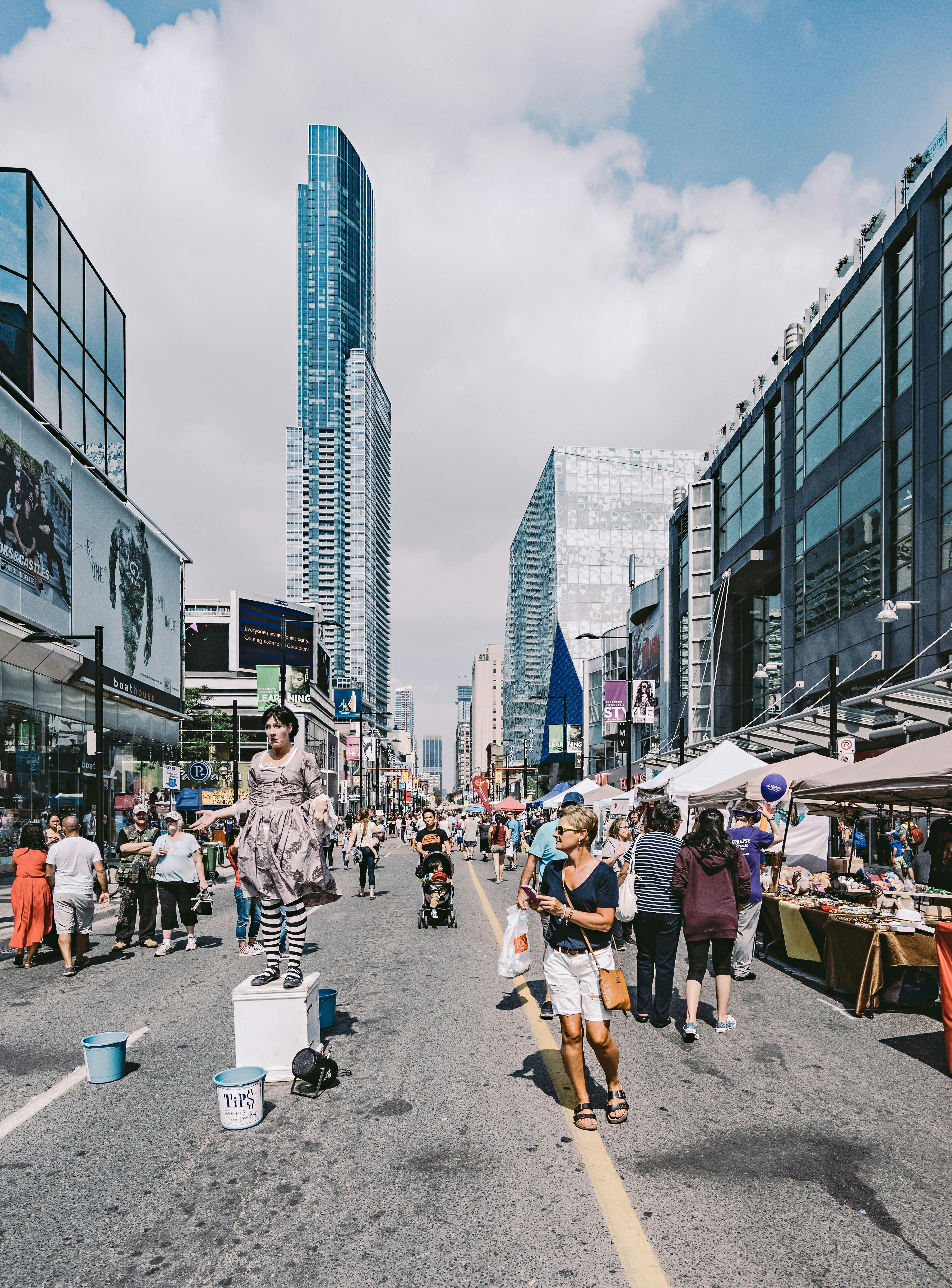 People in the Middle of the Street Under Blue Cloudy Skies