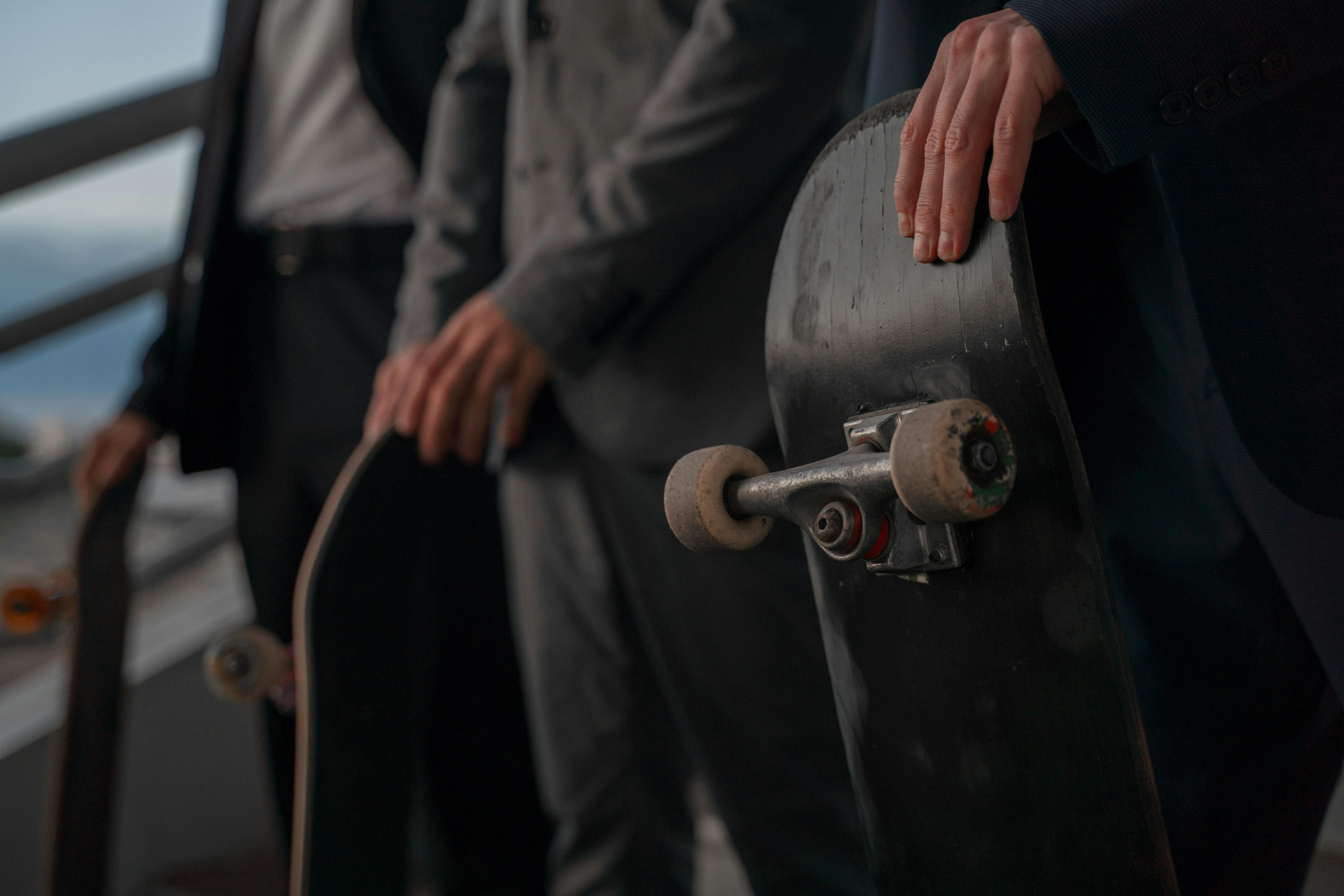 People in Black Suits Holding Skateboards