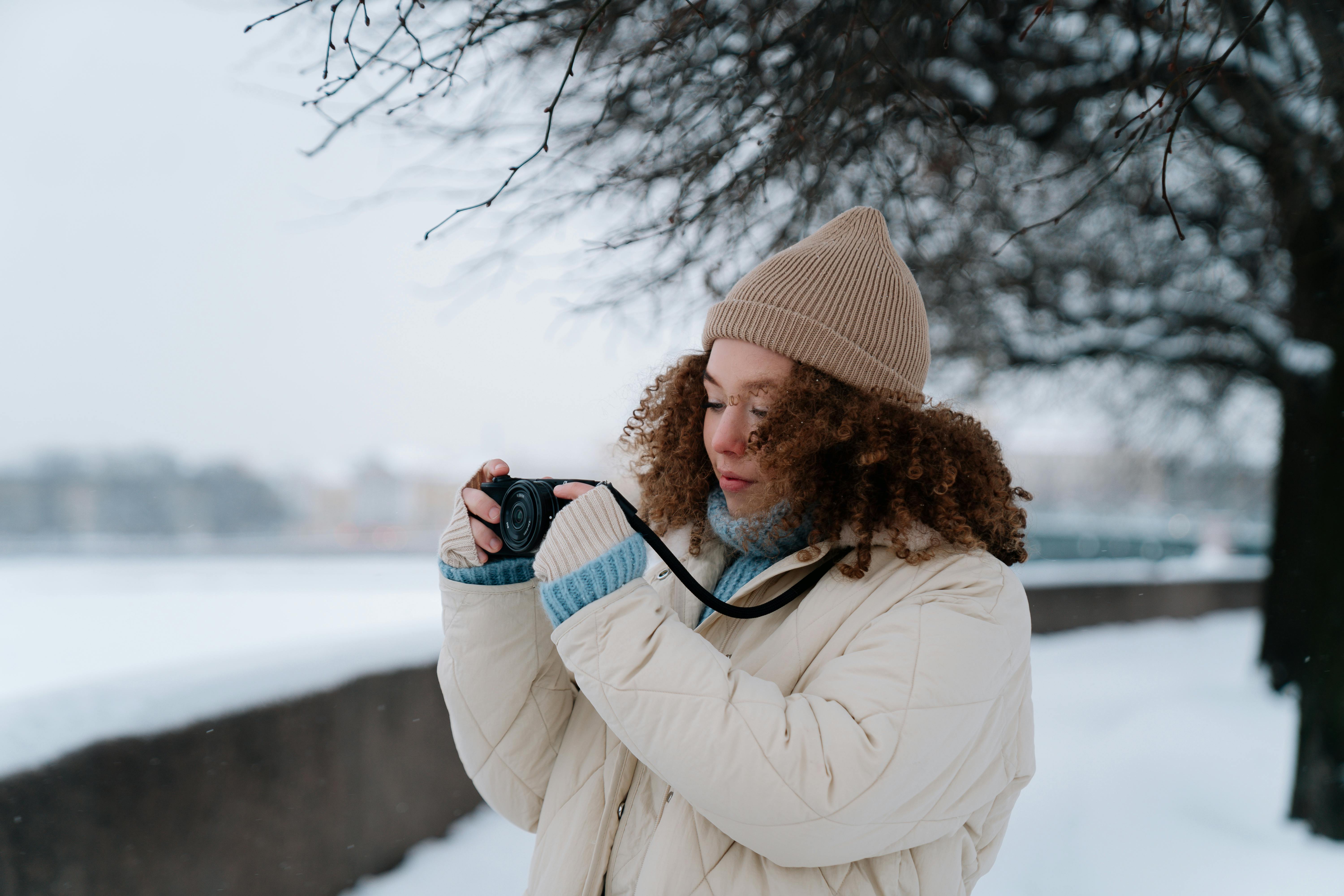 Portrait of Curly-Haired Woman in Jacket Holding Camera