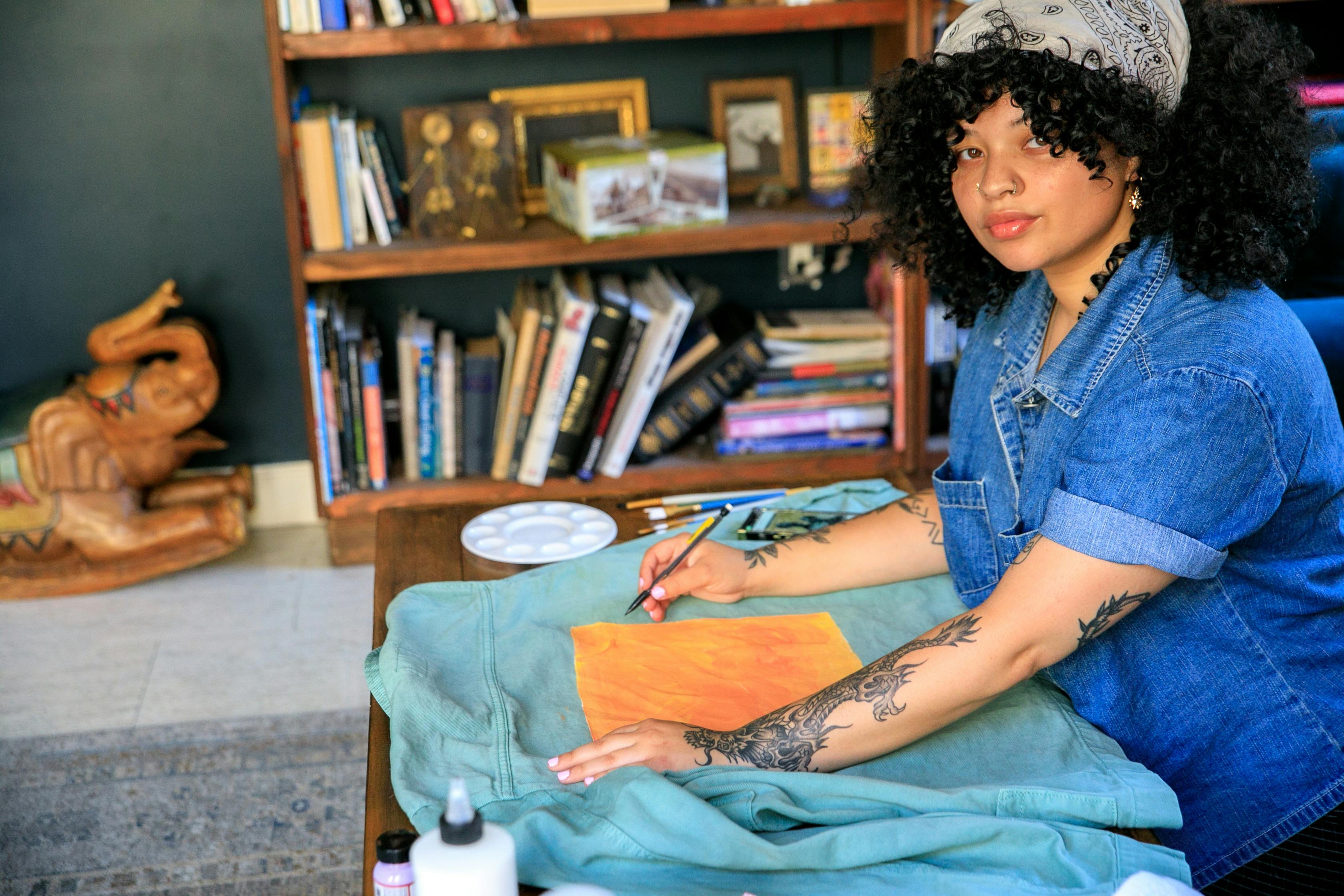 Woman Painting at Home on the Jeans Shirt