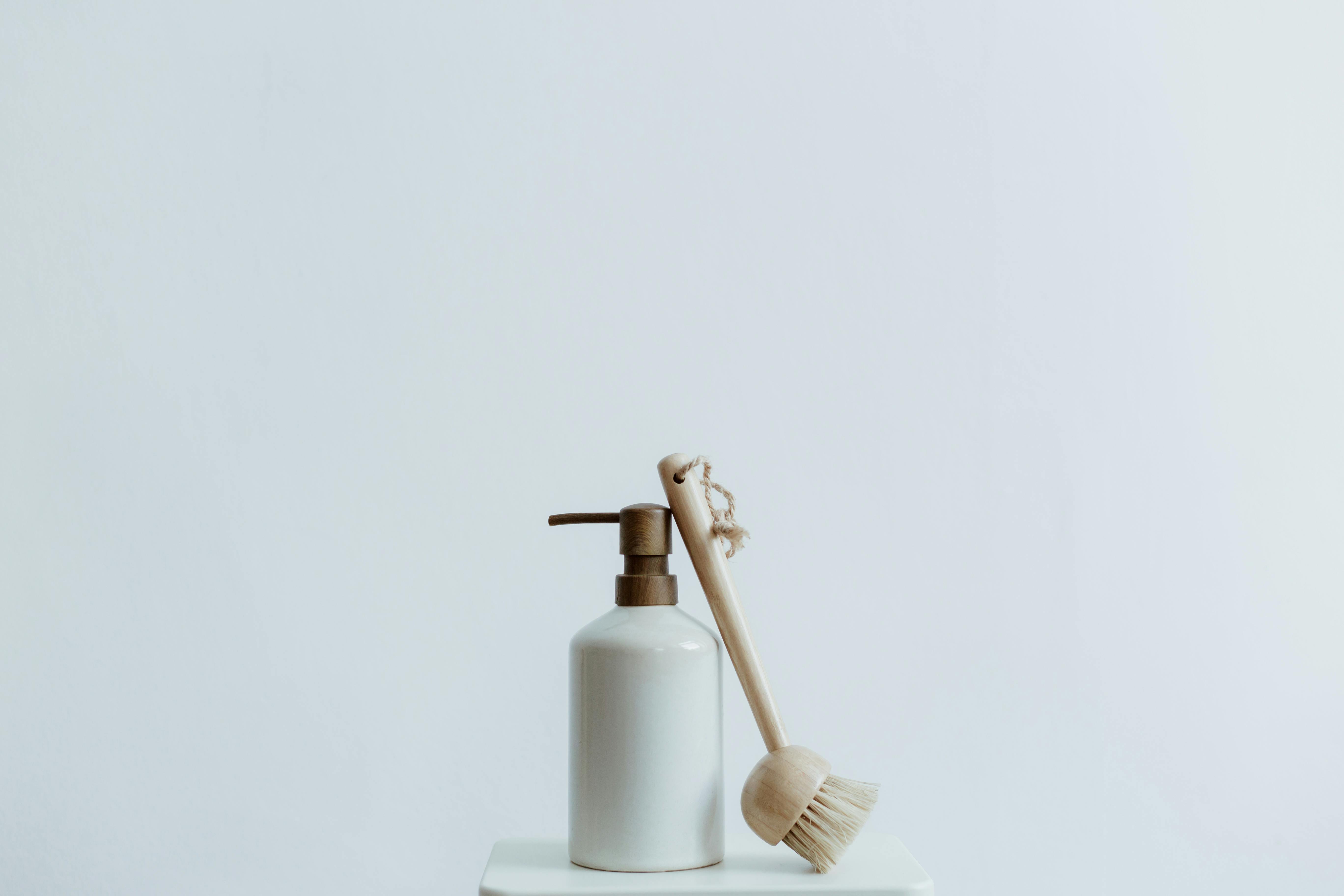 Bottle of Soap and Brush on White Background