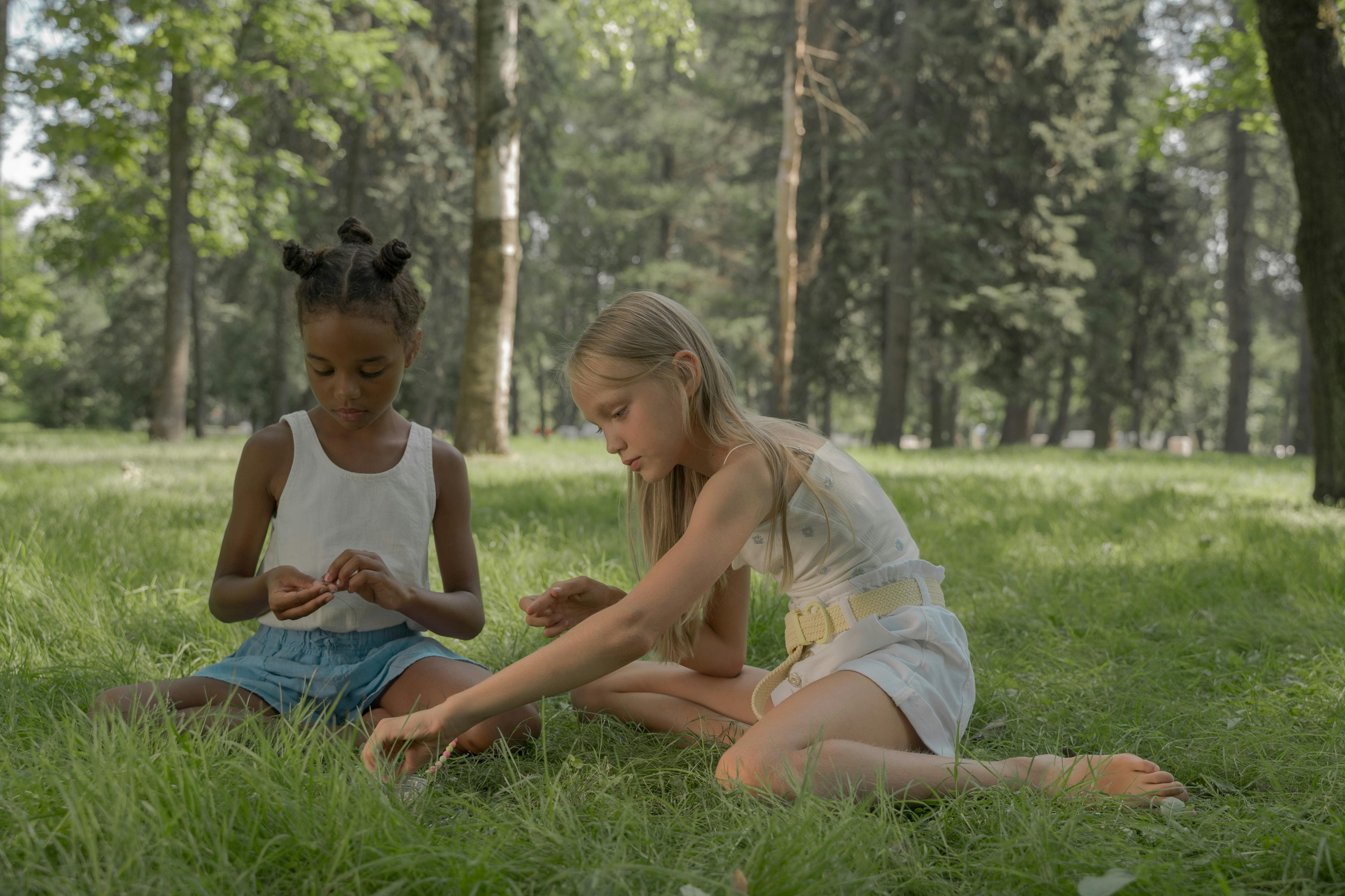 Girls Sitting on Grass Making Beads Necklace