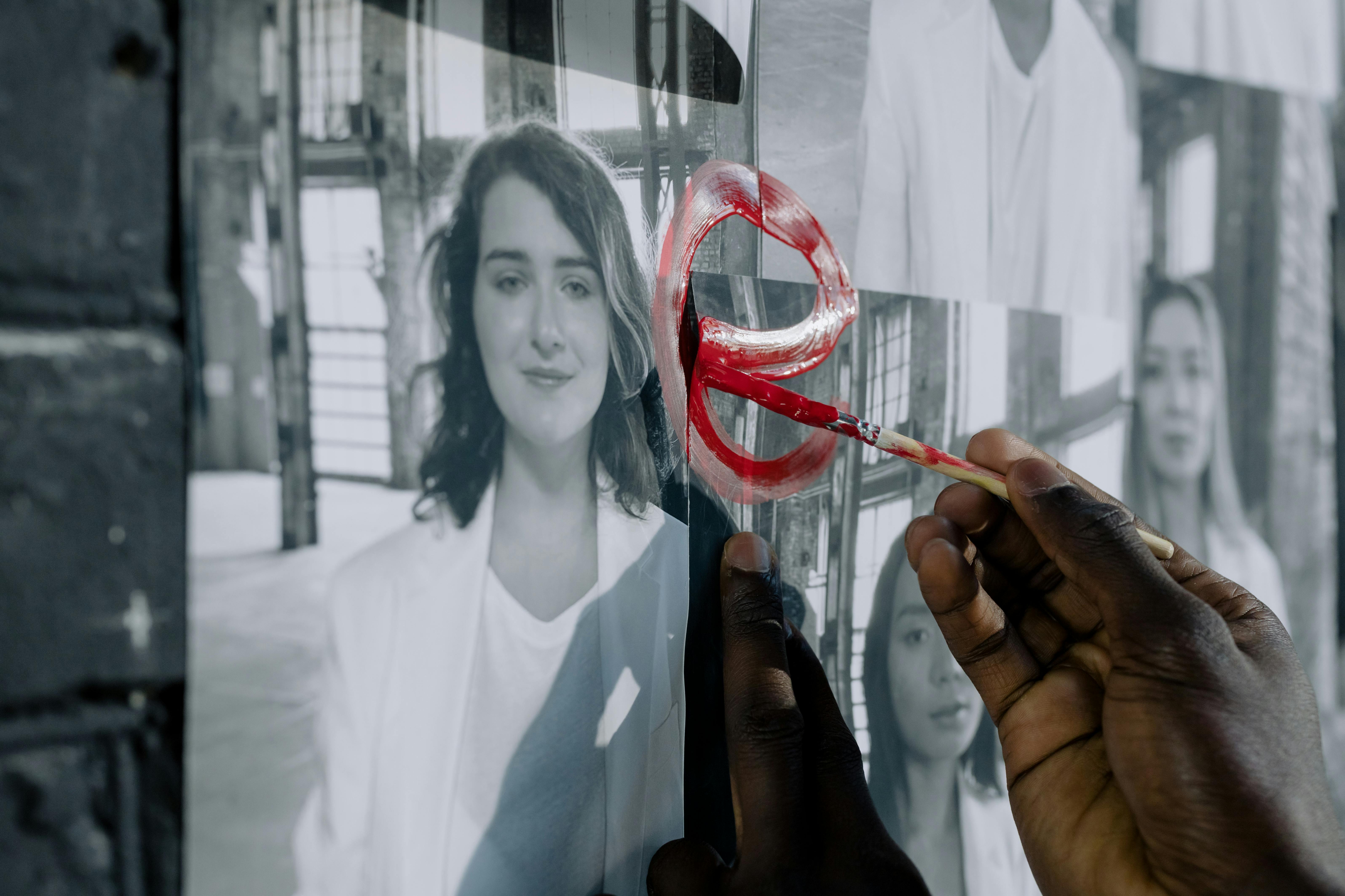 A Person Painting on Pictures of Women