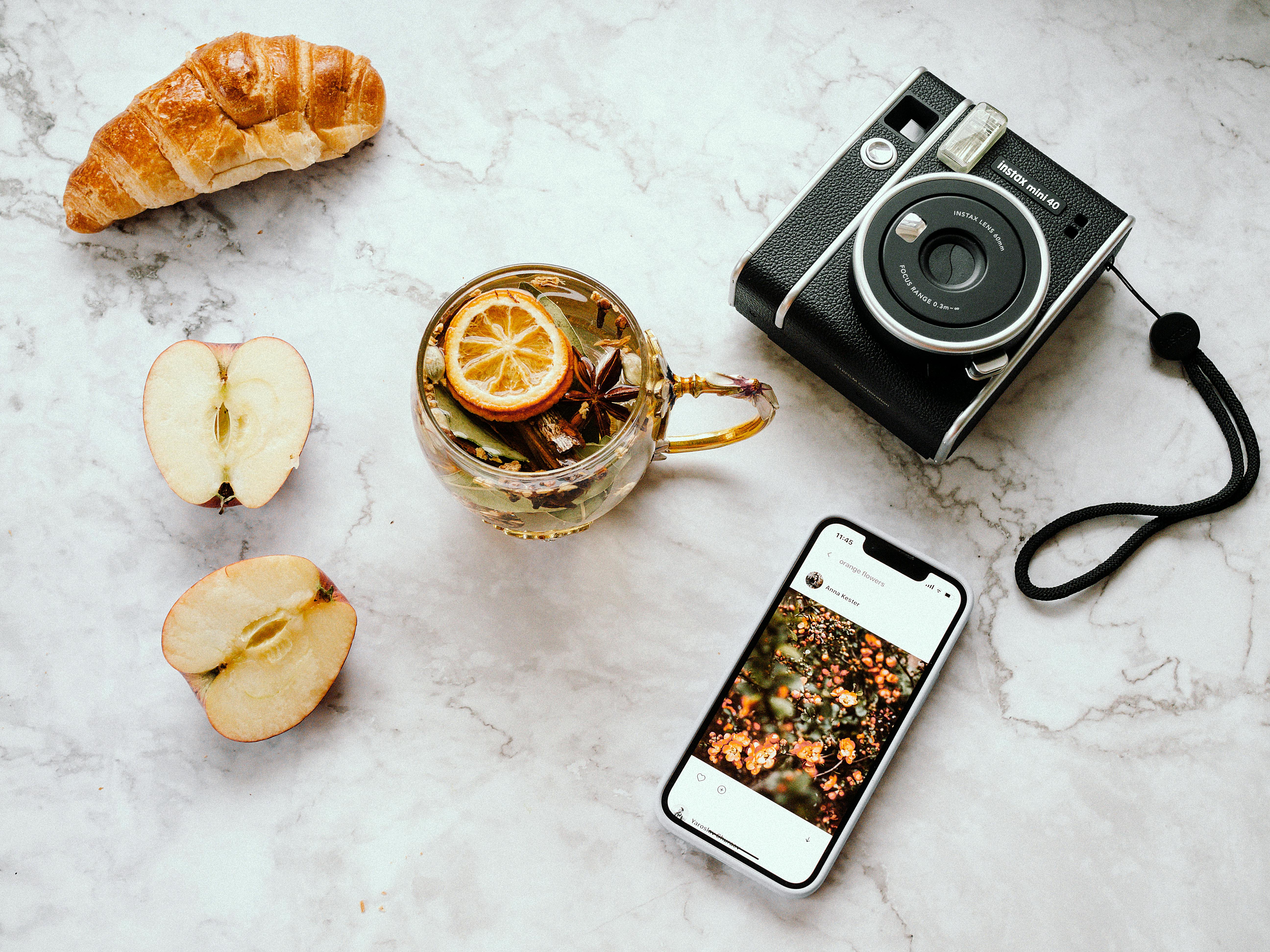 A Cup of Tea with Lemon Lying Next to a Camera and a Phone