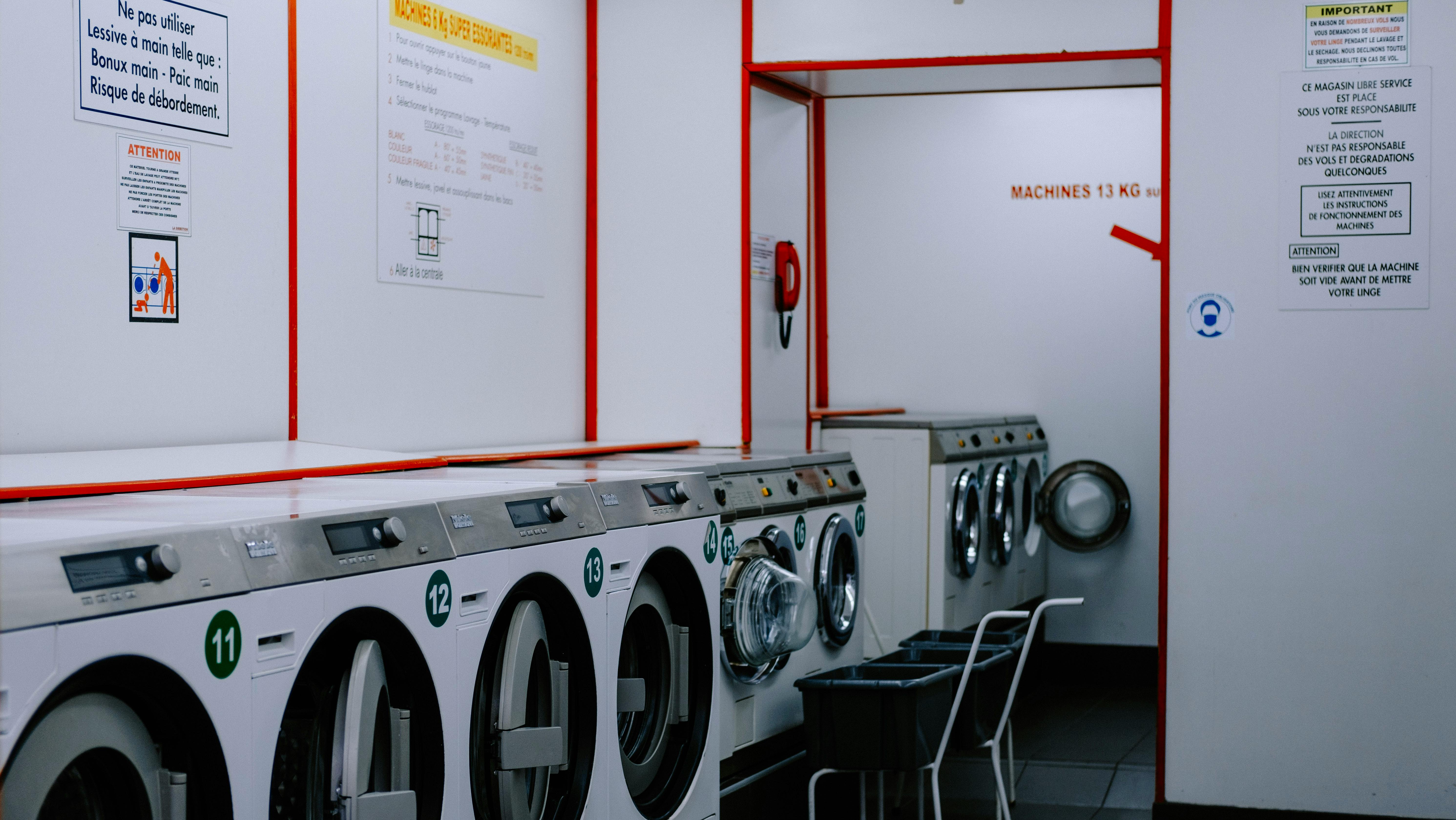 Industrial Washing Machines Lined up Under Wall