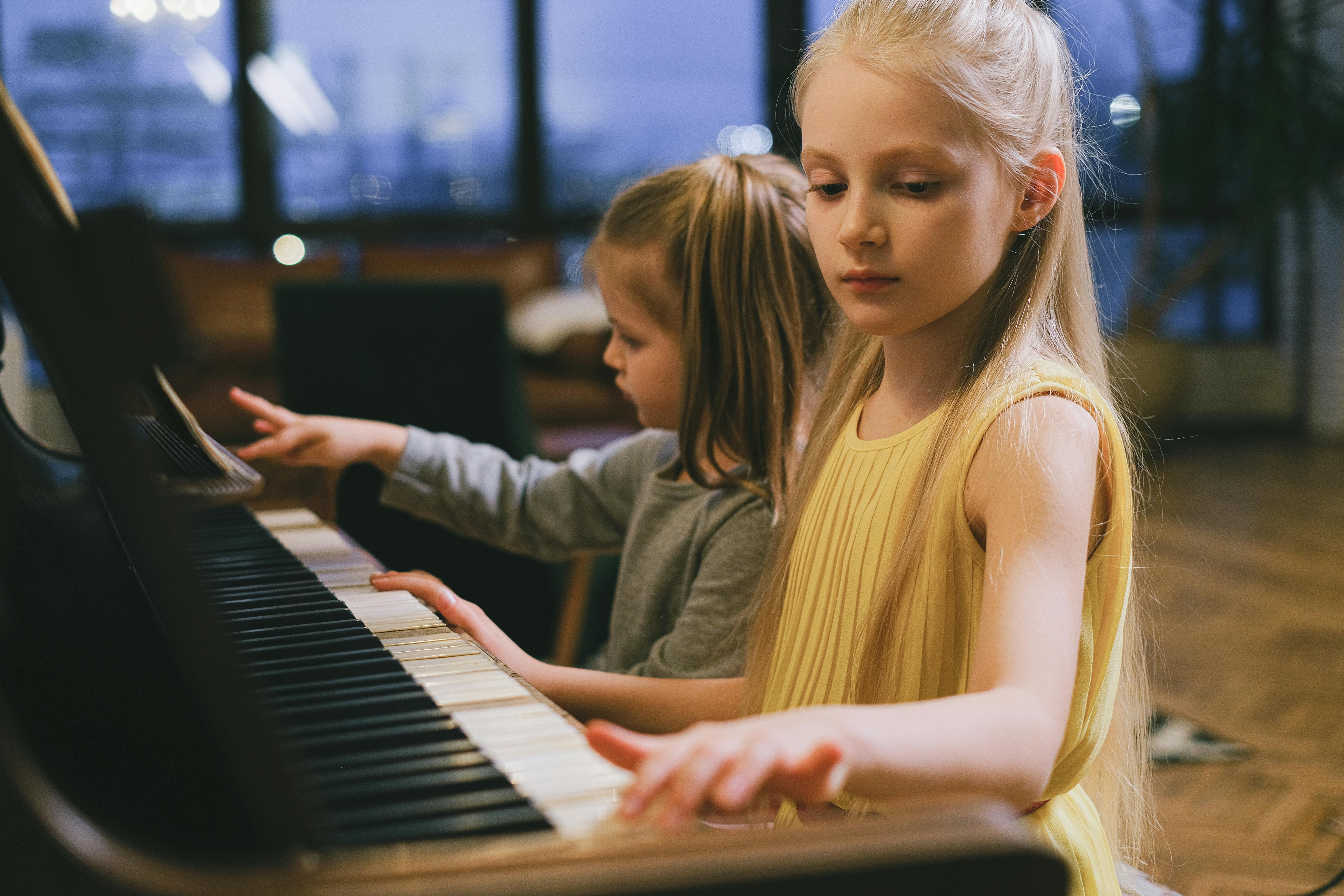 Close Up Photo of Girls Playing Piano