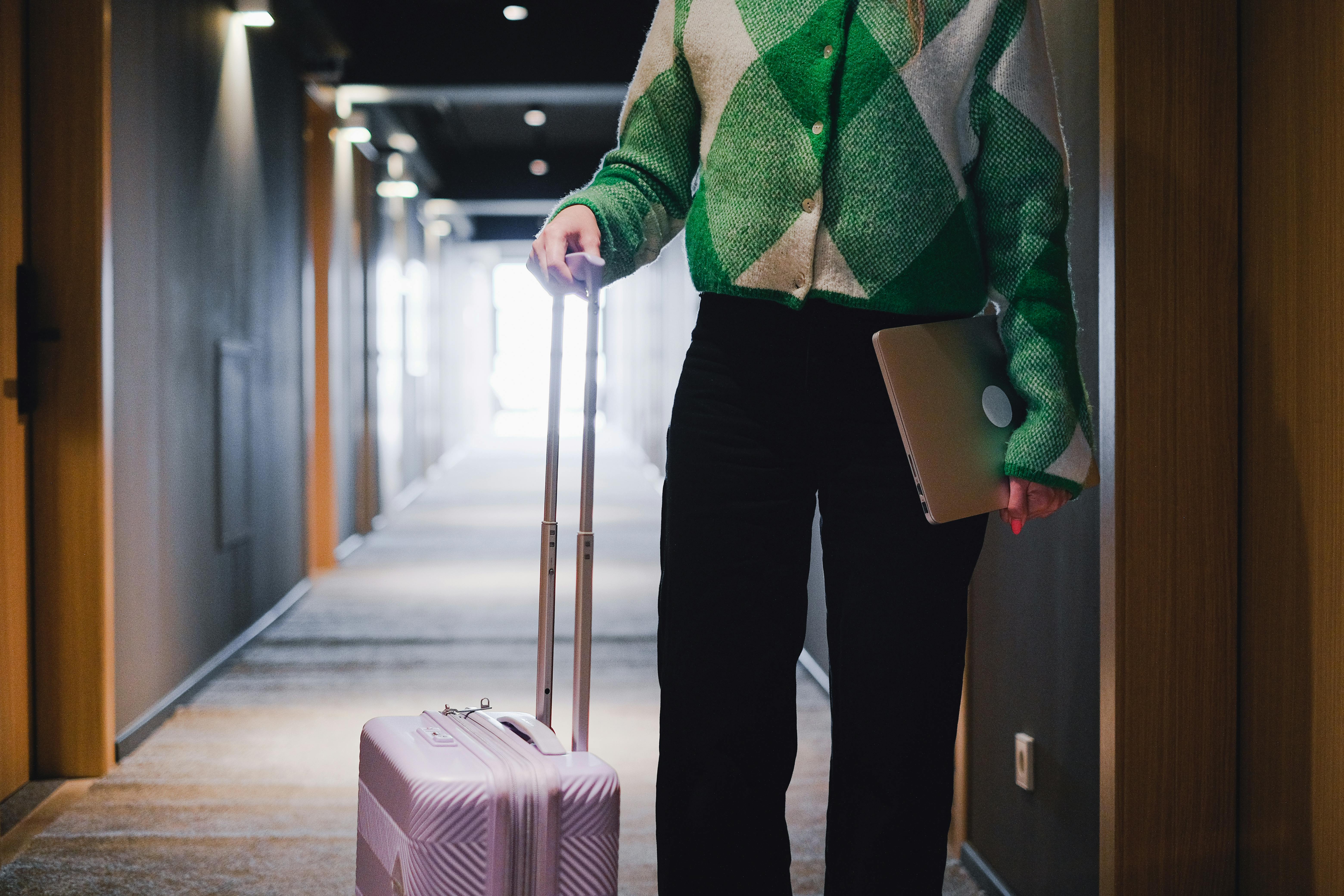 A Person Holding a Laptop and Holding a Luggage