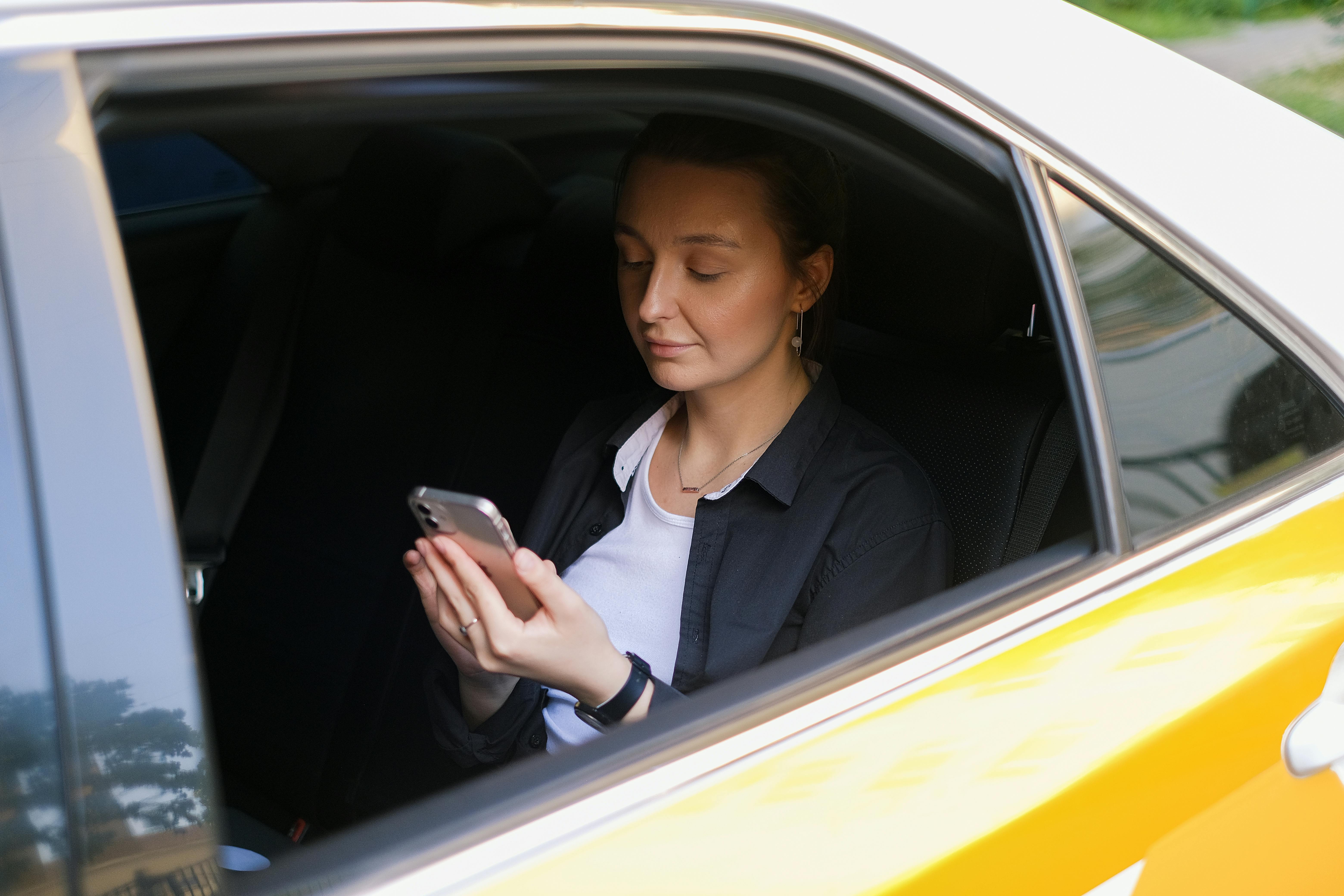 Woman Using a Smartphone while Sitting inside a Car