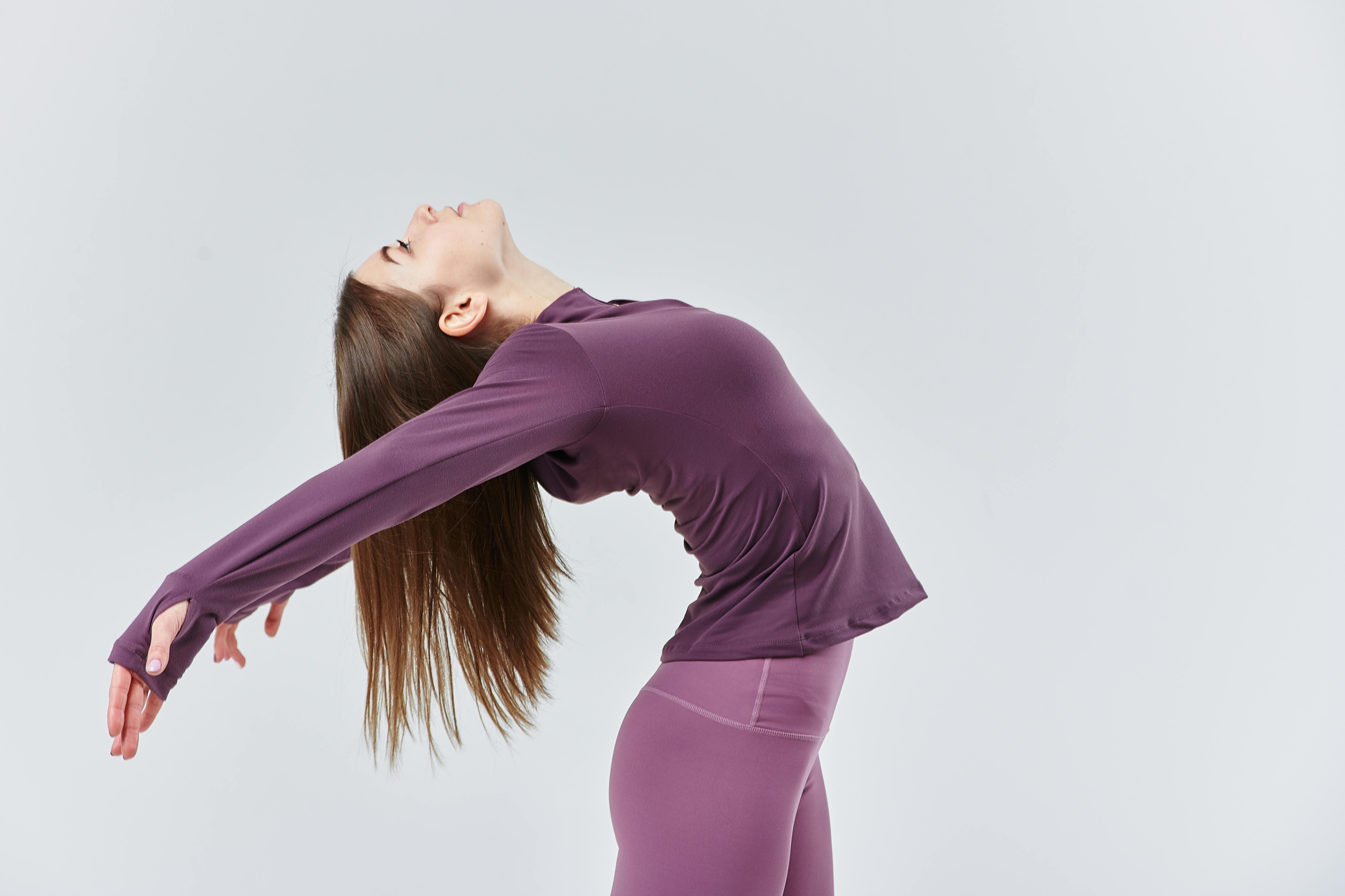 Flexible girl on the white background in sport clothes