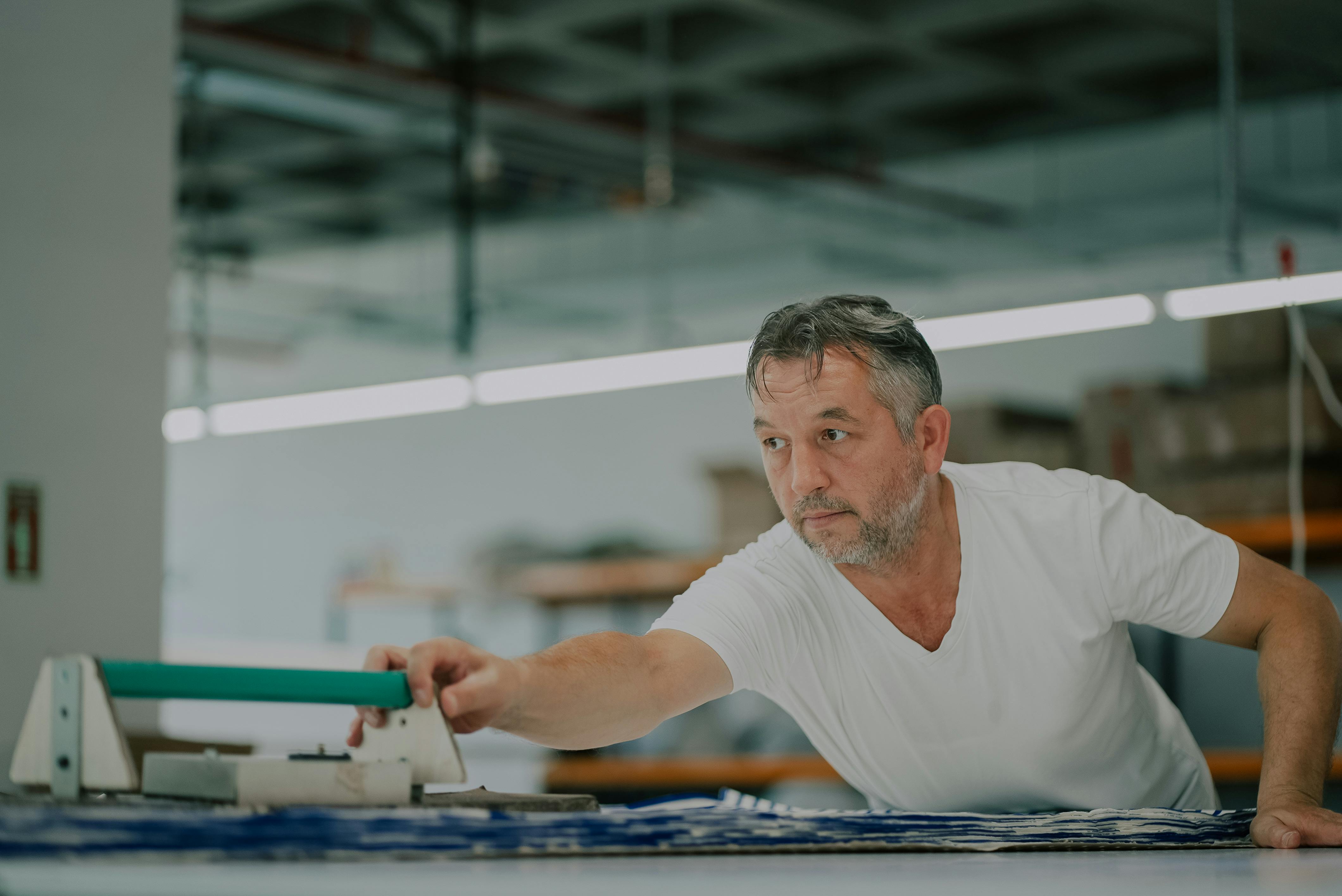 Man Working with Fabric in Workshop