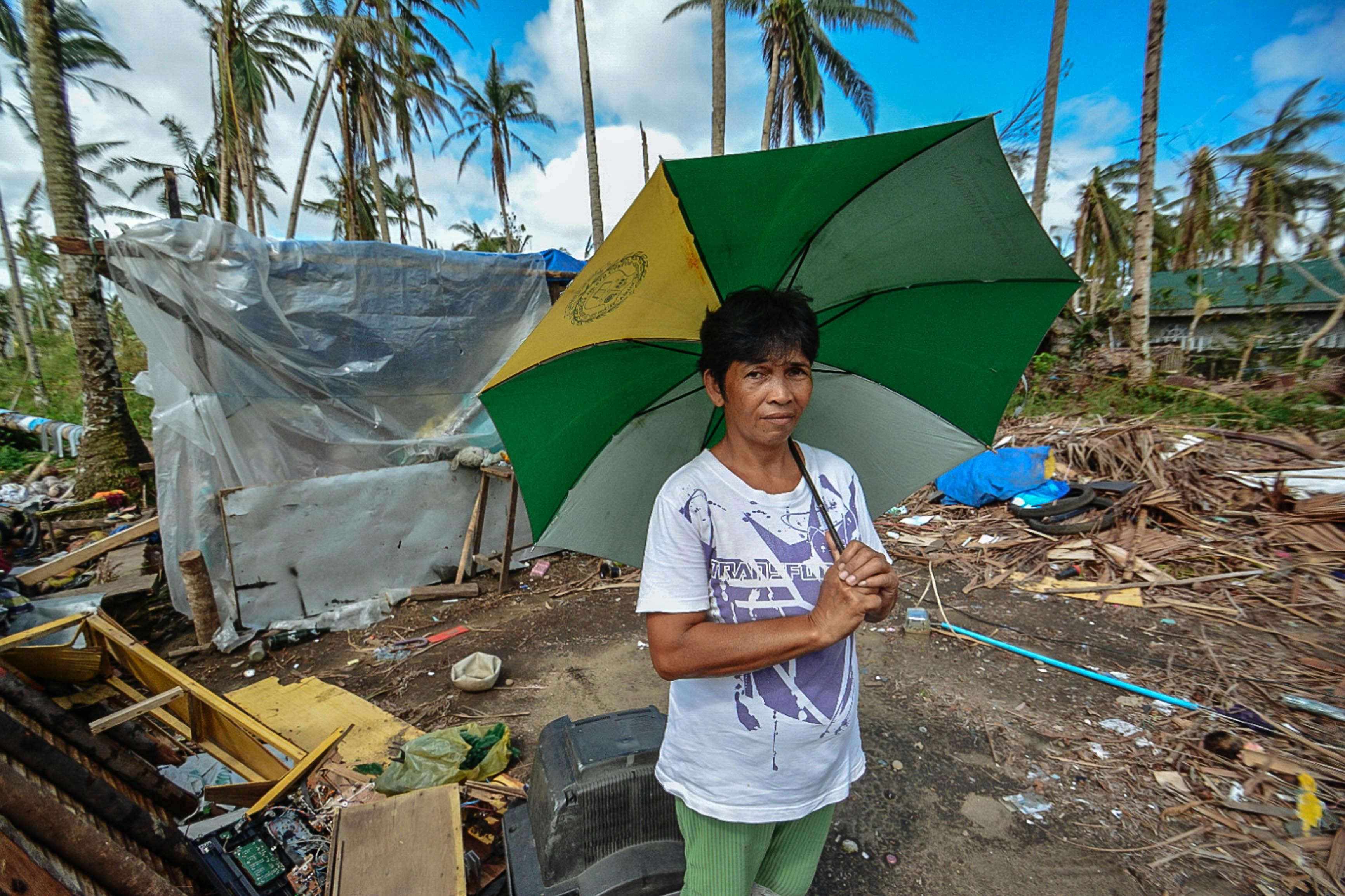 Woman Holding Green, Yellow, and White Umbrella Standing Near Black Crt Tv