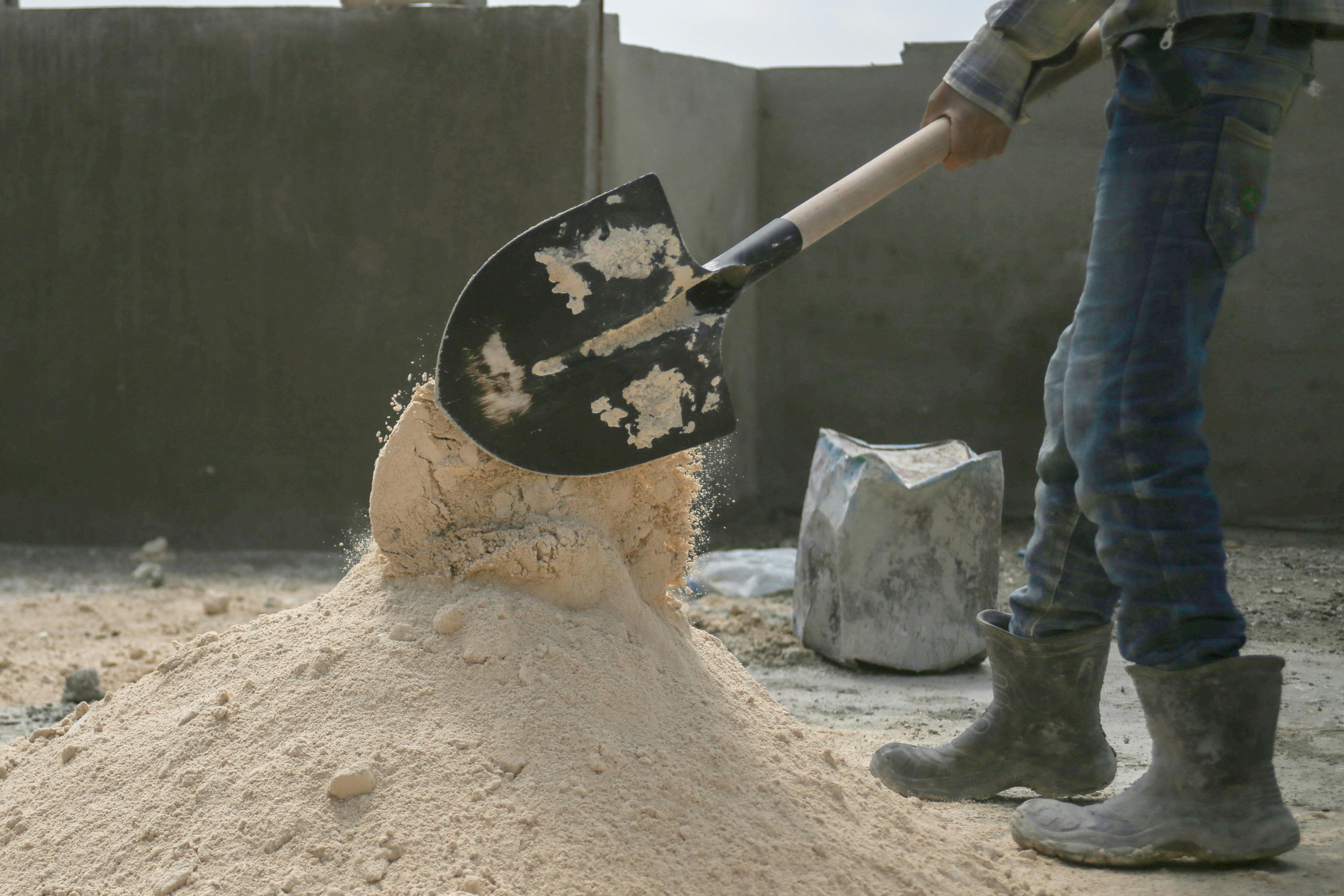 Man Working with Shovel on Construction Site