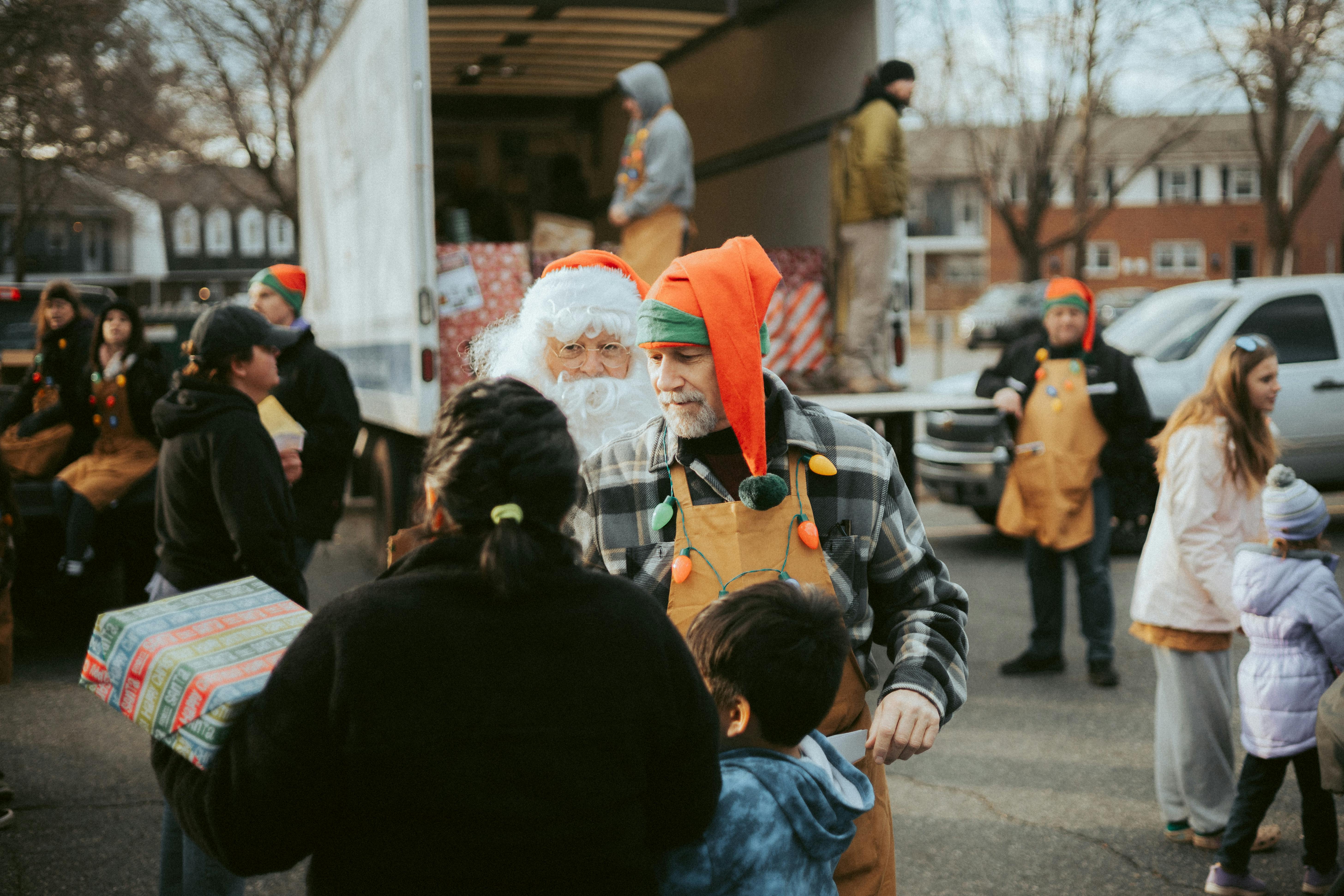 People in Christmas Costumes Giving Away Presents on the City Street