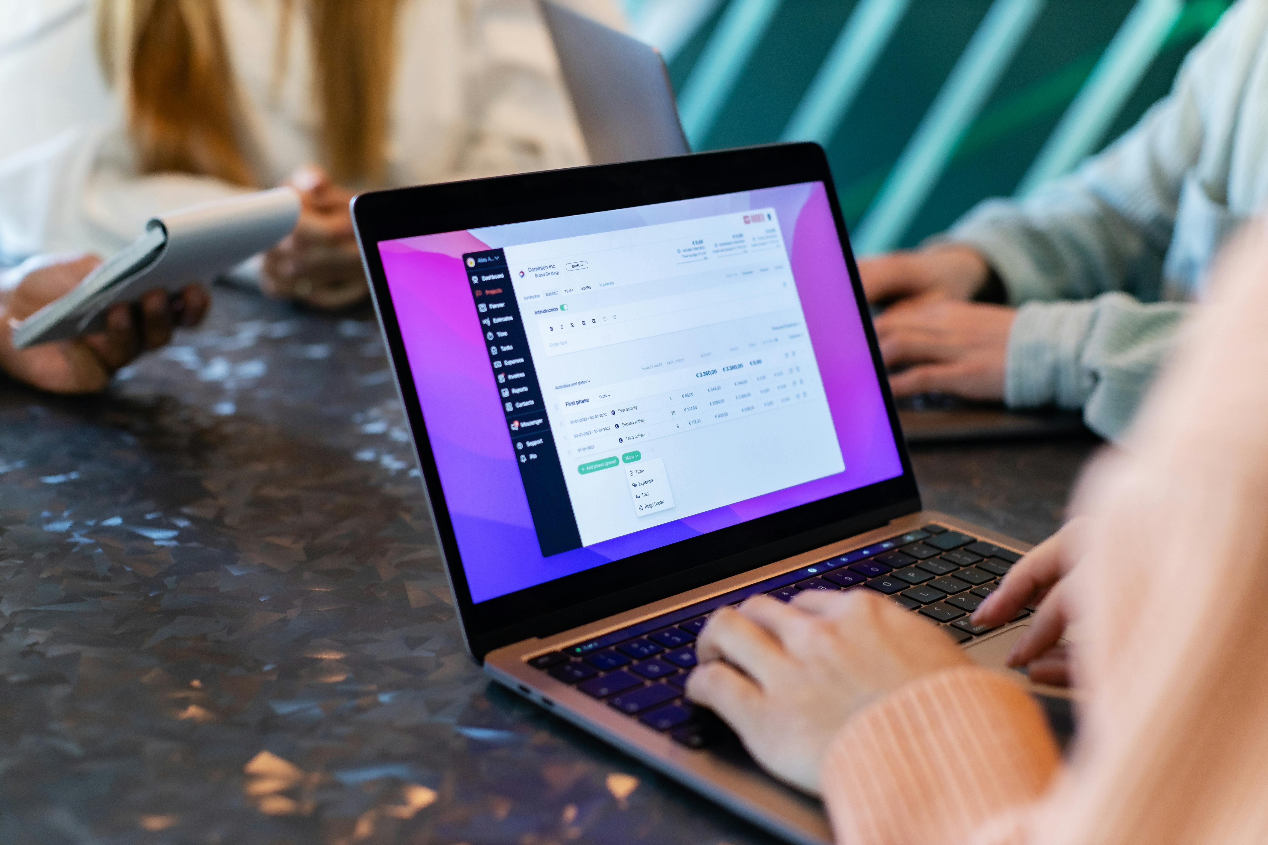 Woman Using a Laptop during a Business Meeting