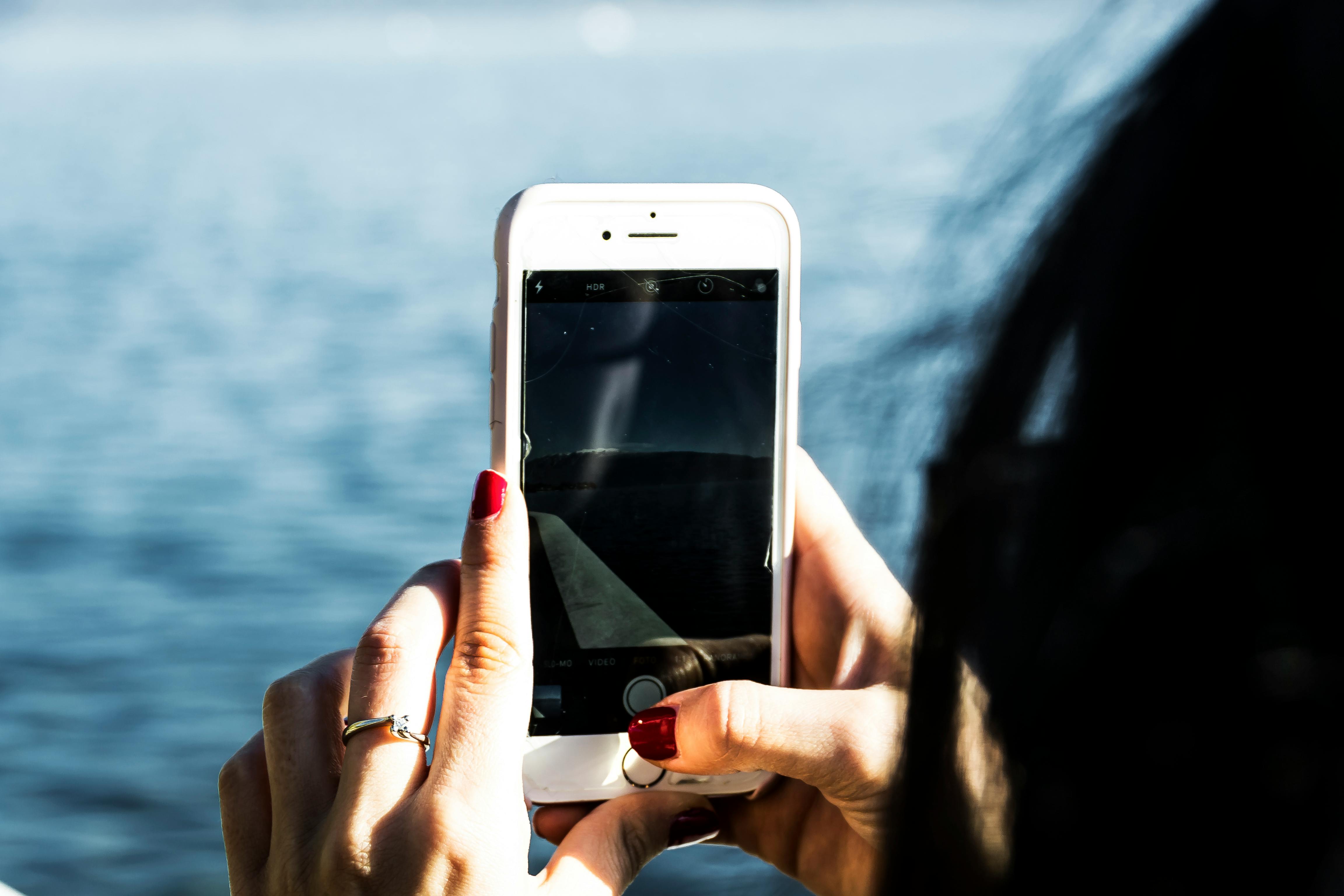 Person Taking Photo Of Body Of Water Using Iphone