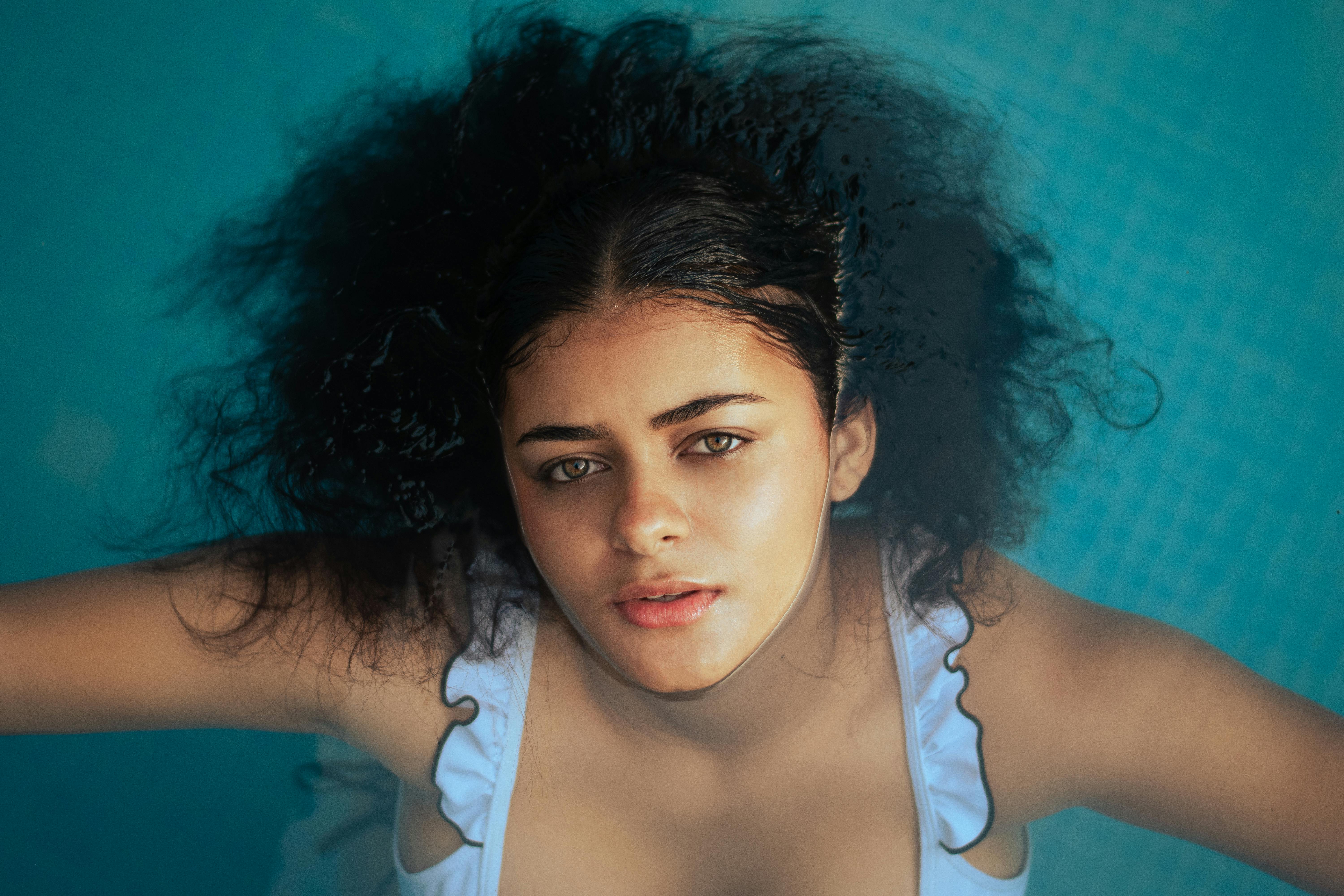 Young Woman Floating on Water in Pool