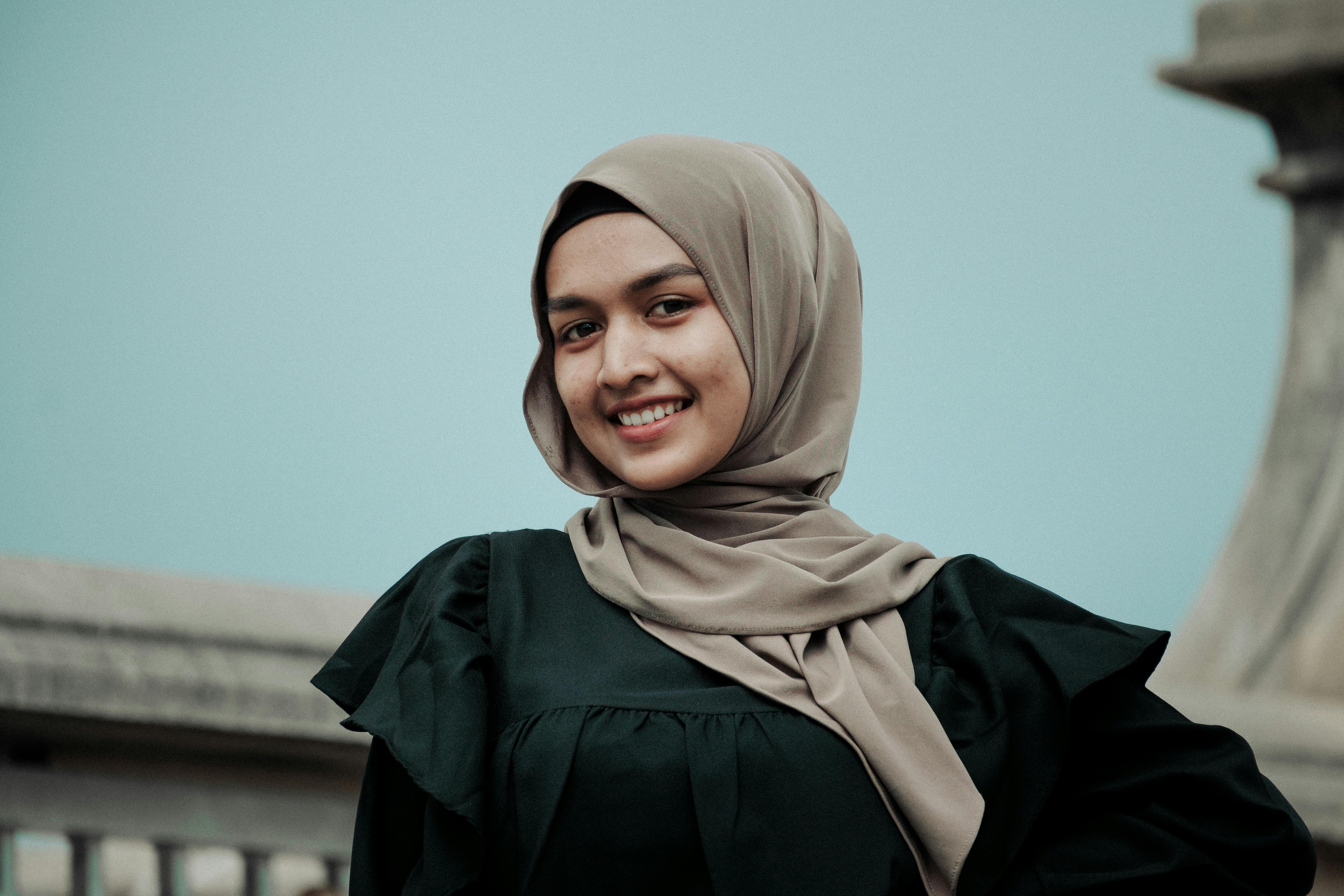 Young Woman in a Hijab Standing Outside and Smiling