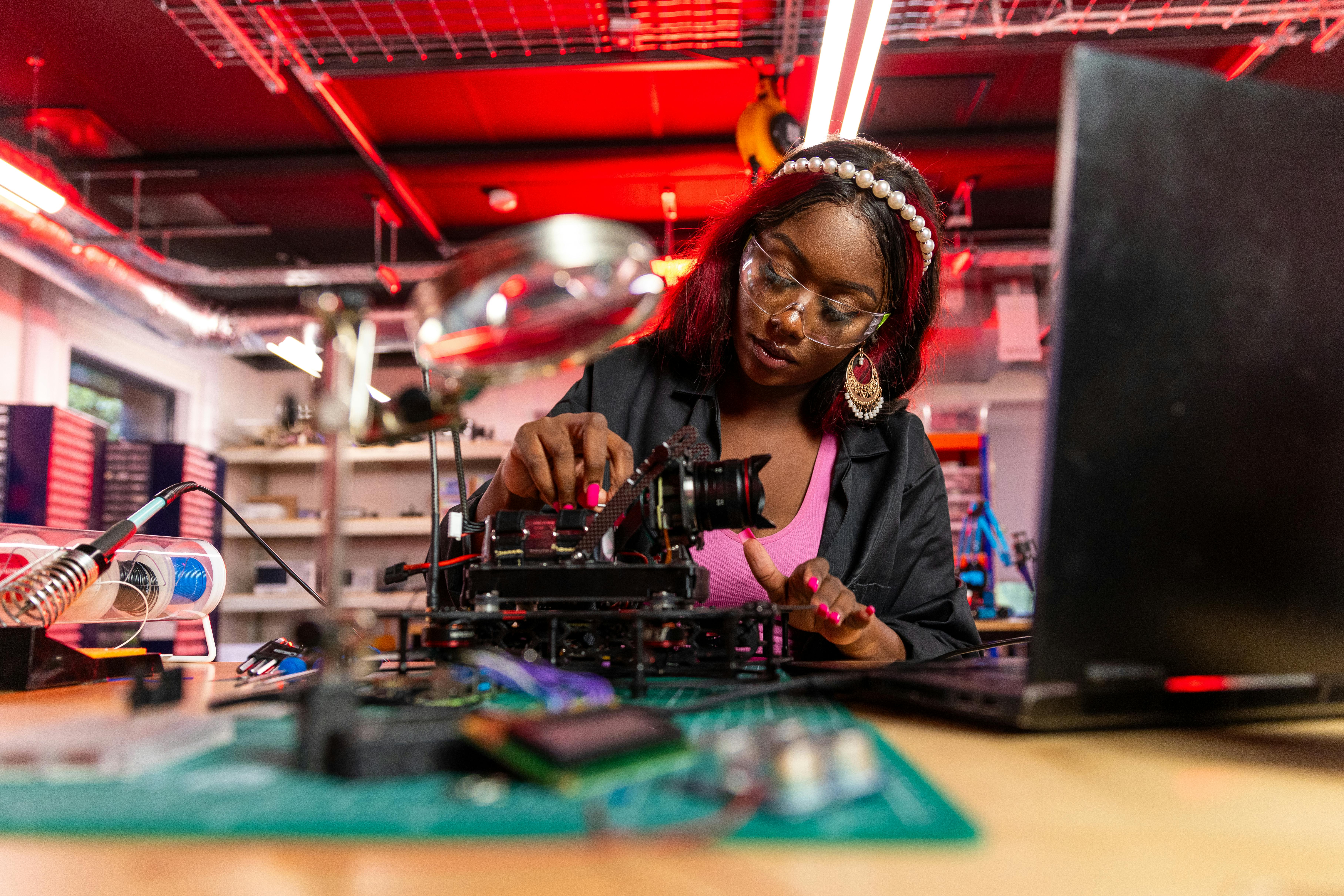 Woman in a Repair Shop Fixing a Digital Camera