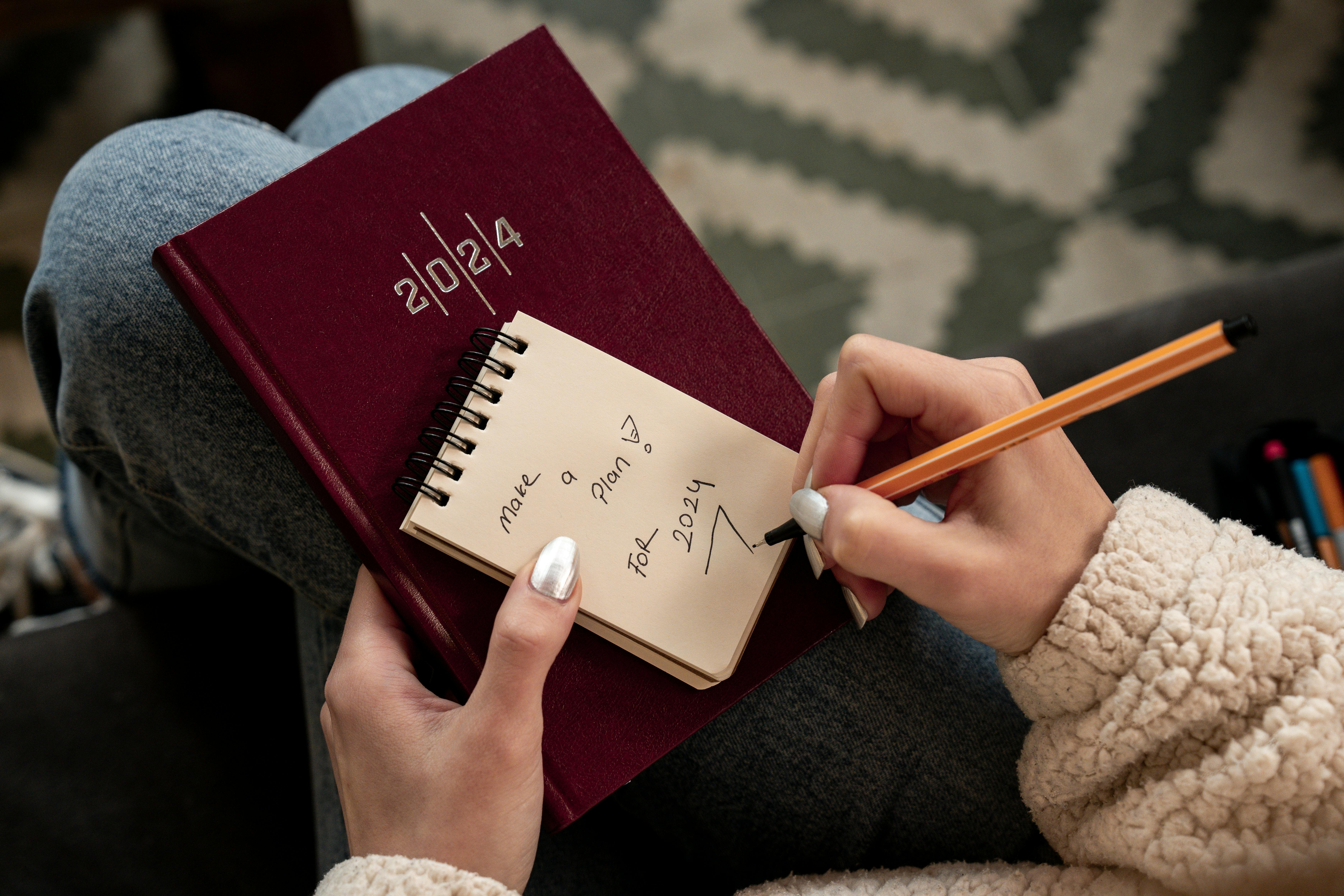 Woman Hands Holding Notepad and Writing