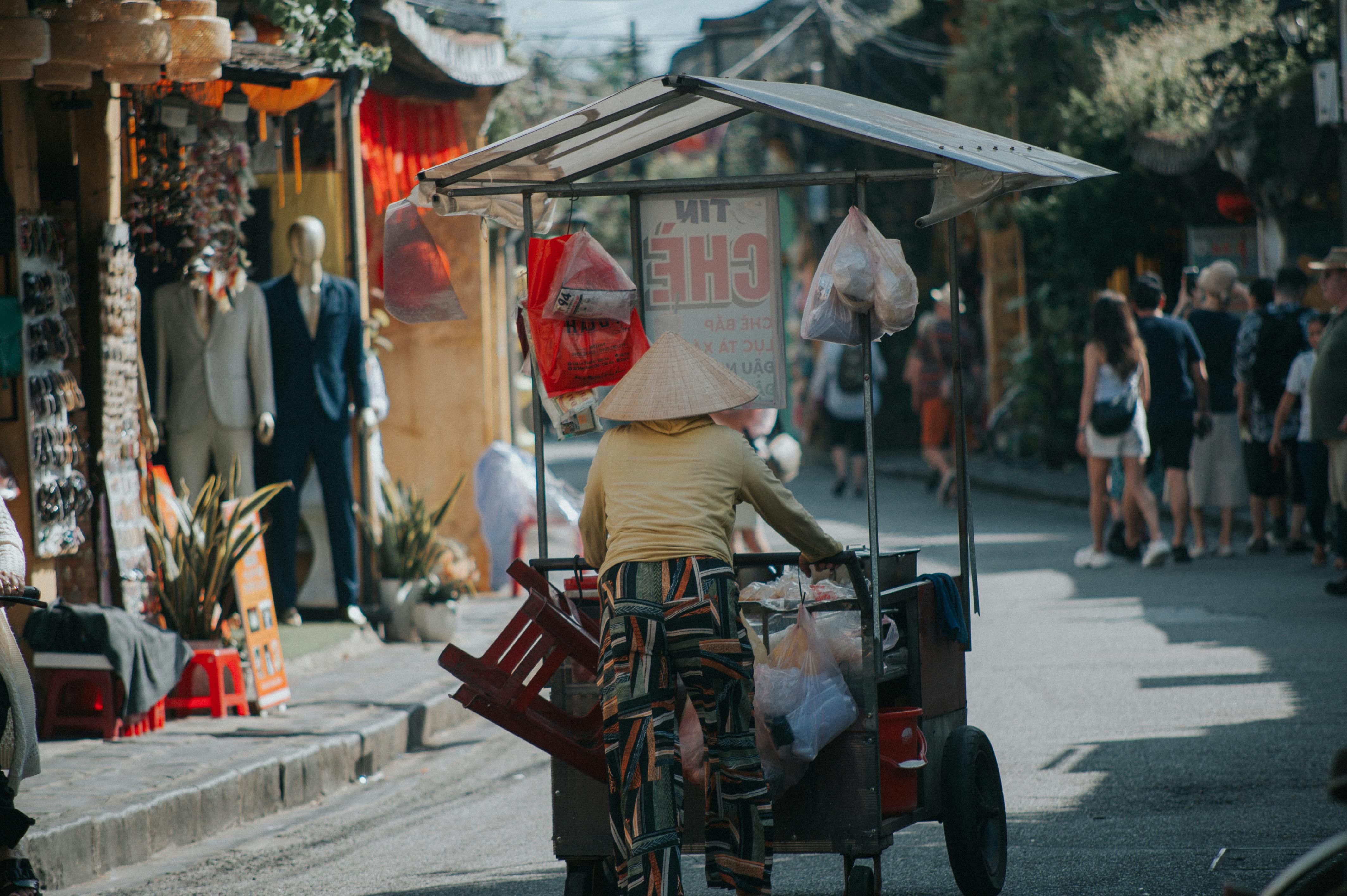 Woman in Conical Hat Riding Bike with Trailer