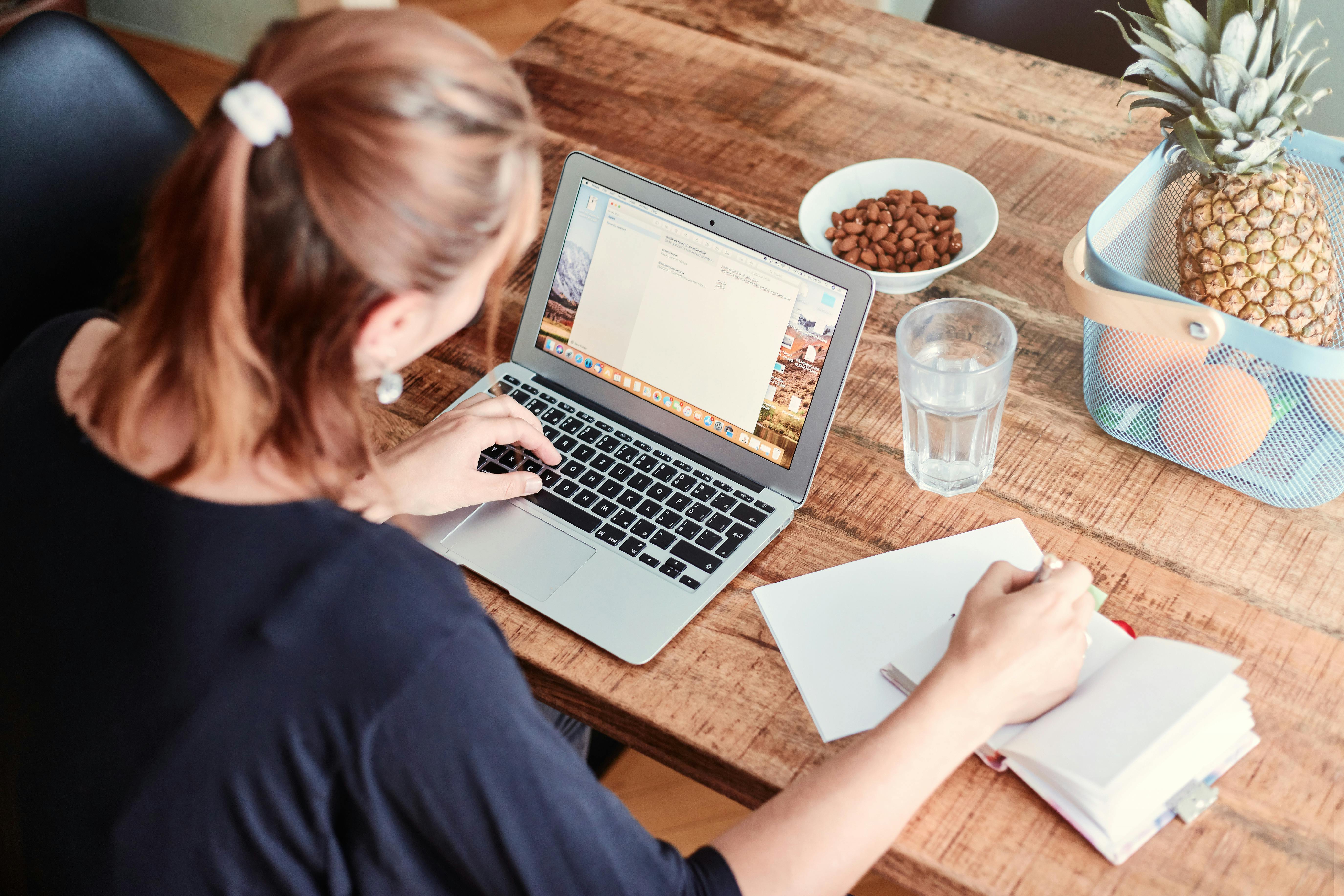 Woman Sitting at Dinning Table with Laptop