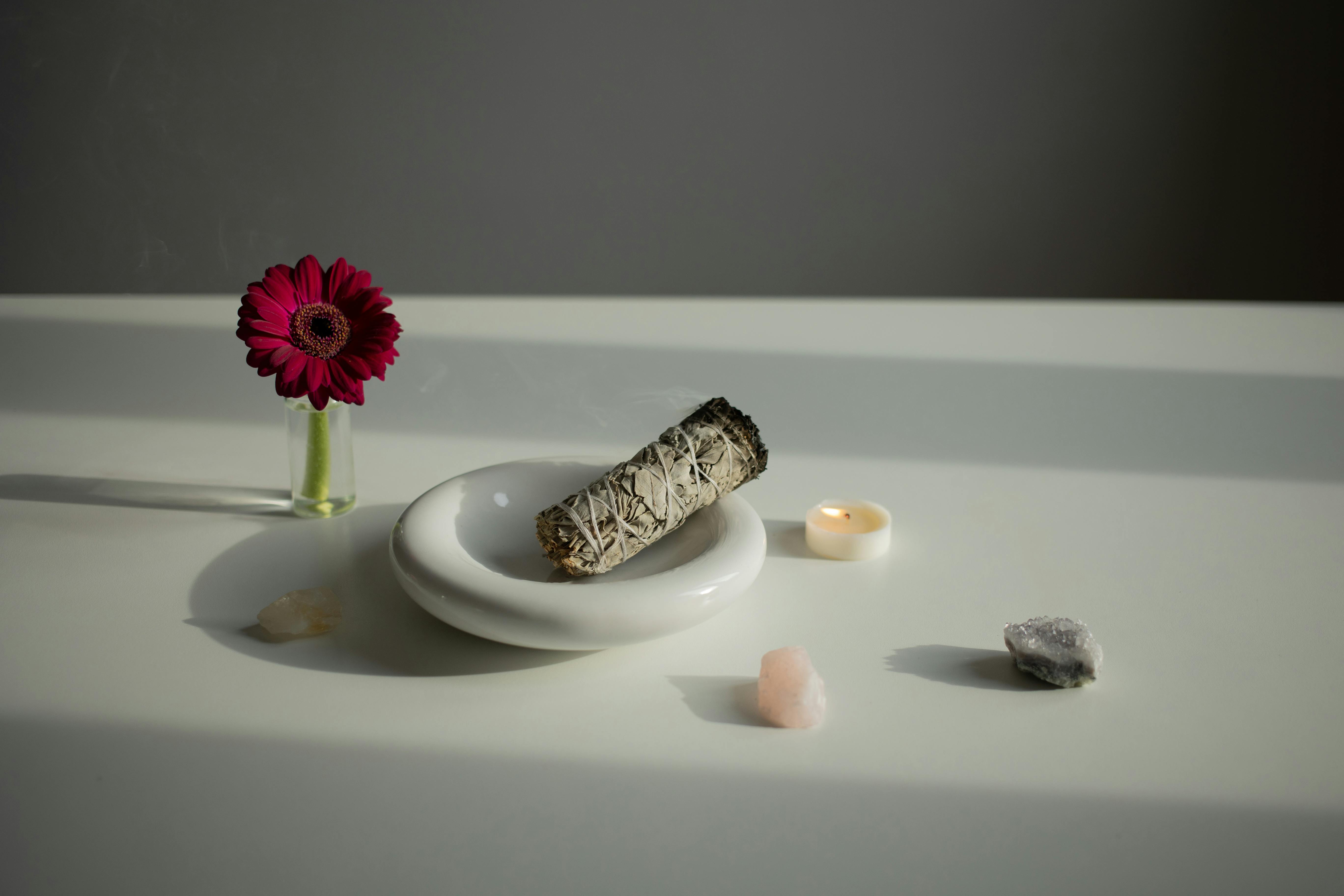 Incense on a White Plate, Crystals and a Gerbera Flower on a Table