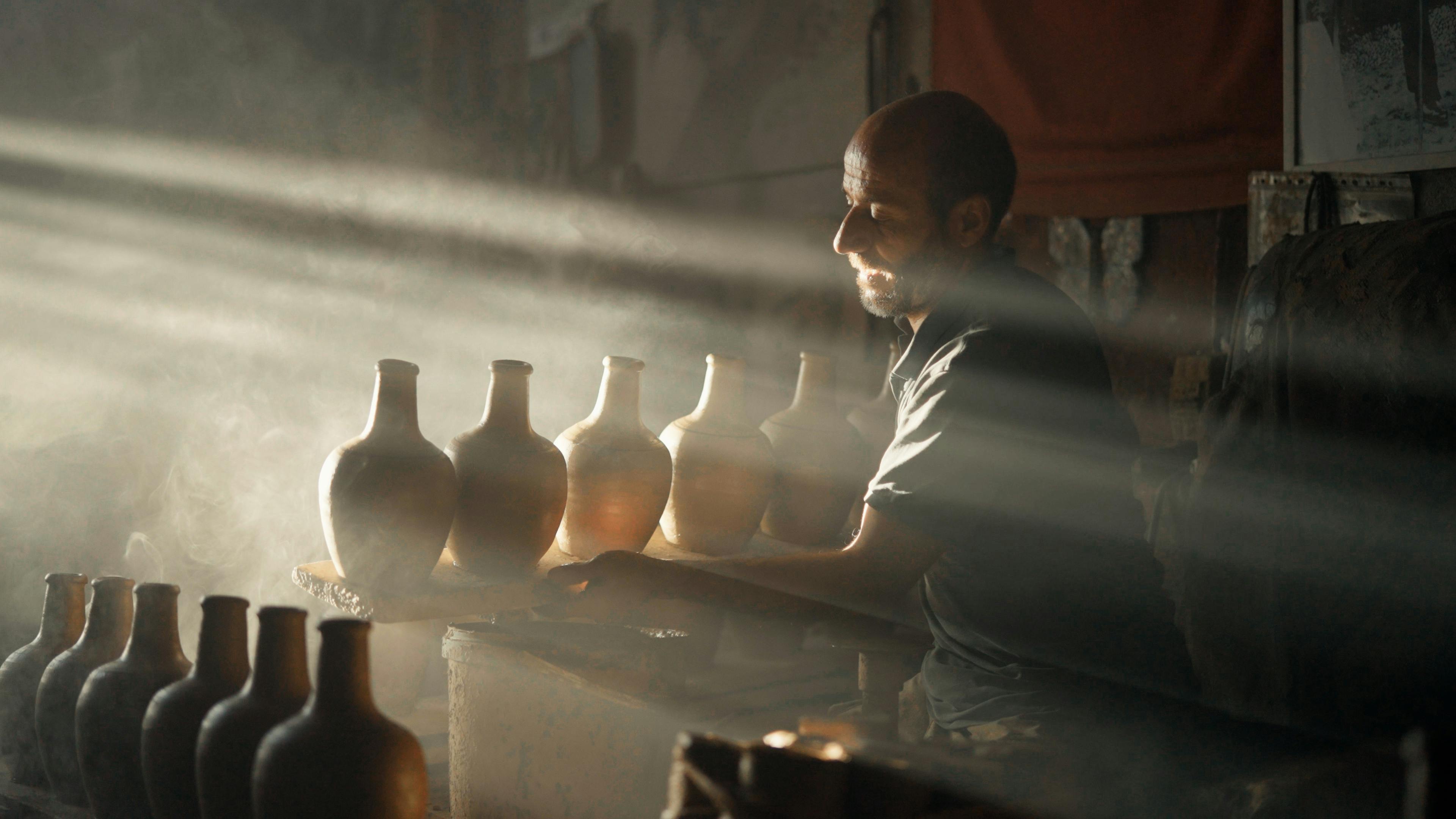 A man is working in a room with vases