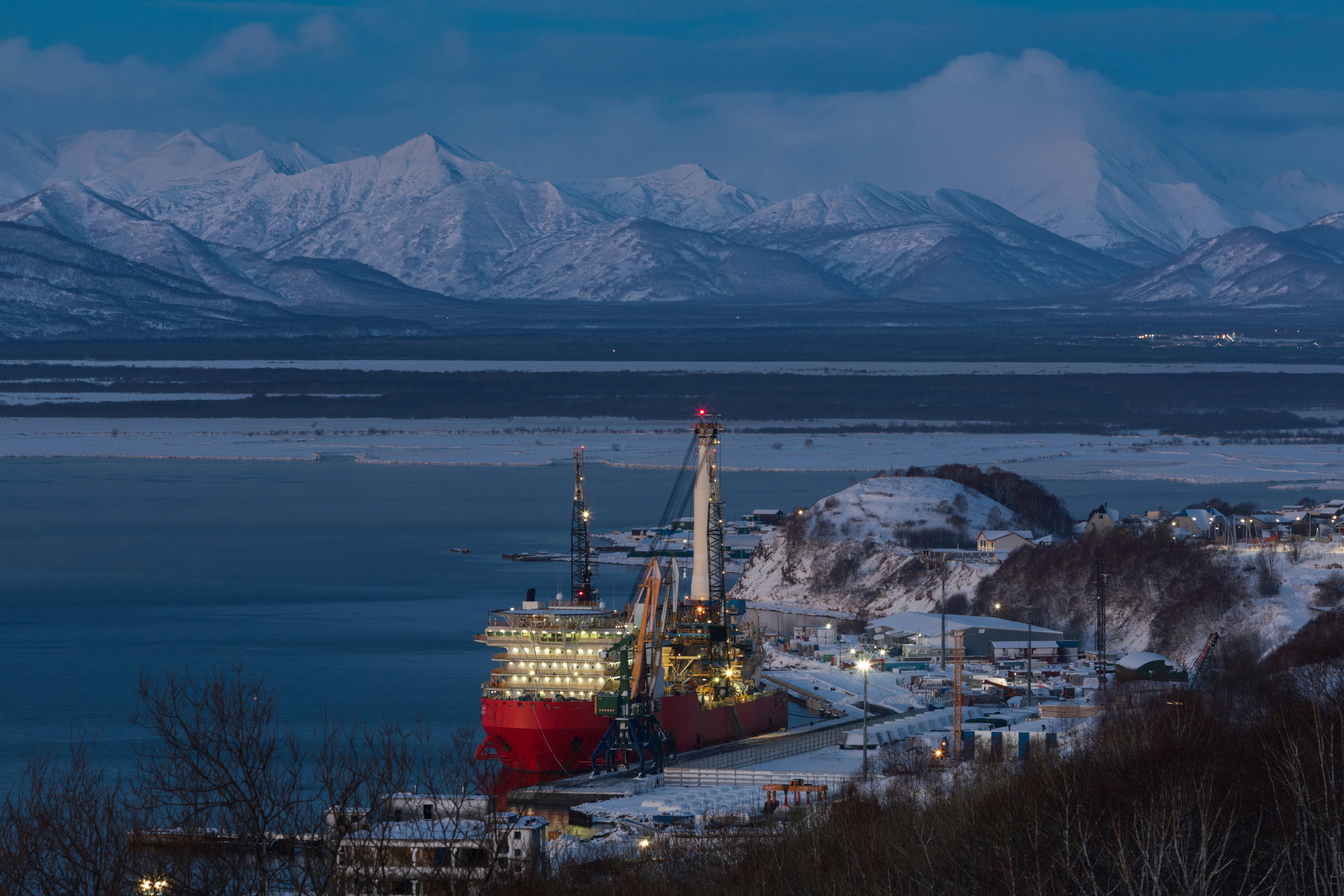 View of a Large Ship in a Port near Snowcapped Mountains
