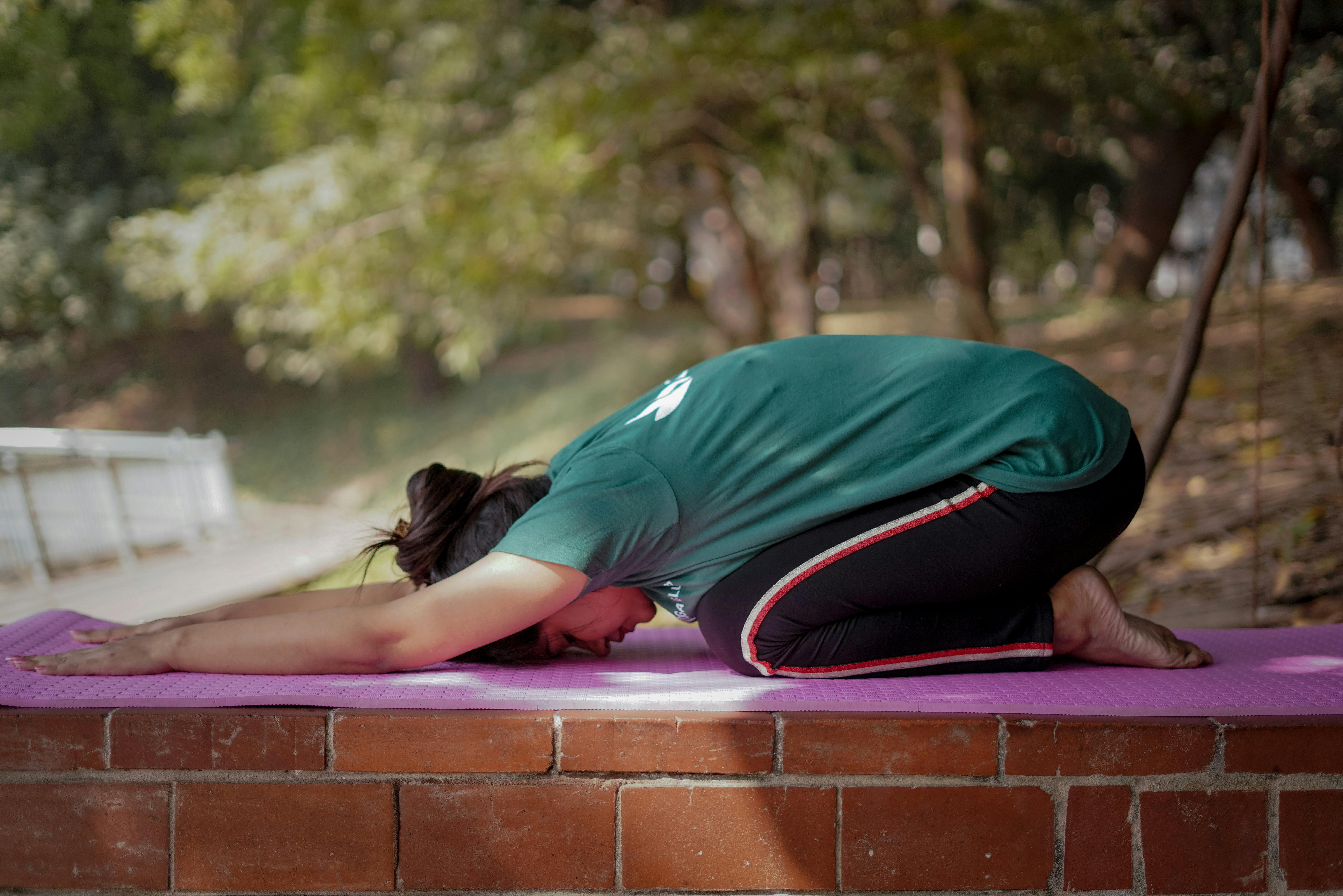 Woman Kneeling and Exercising Yoga on Mat