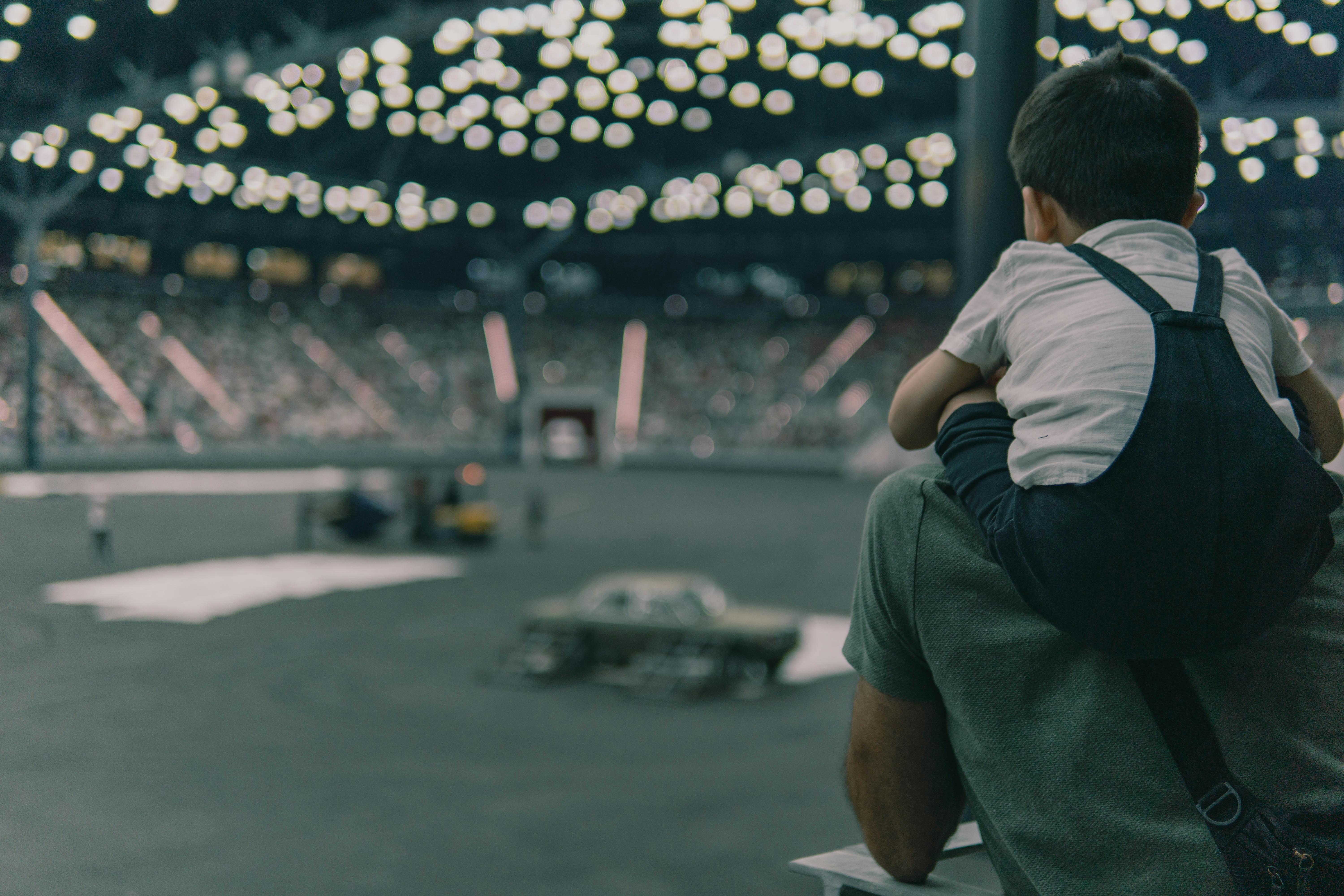 Boy Sitting on Father at Motorsport Event at Stadium